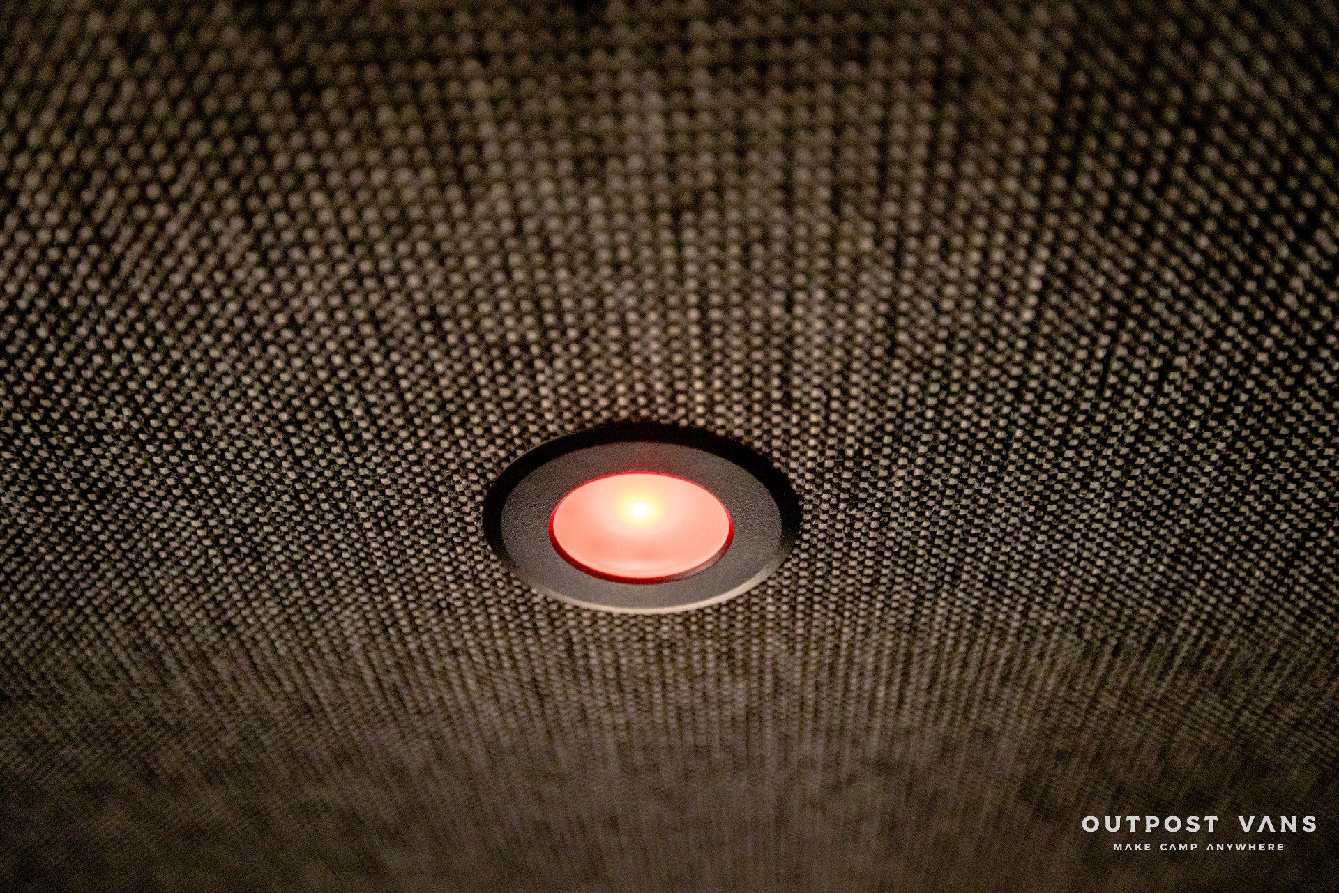 A red light is hanging from the ceiling of a room.