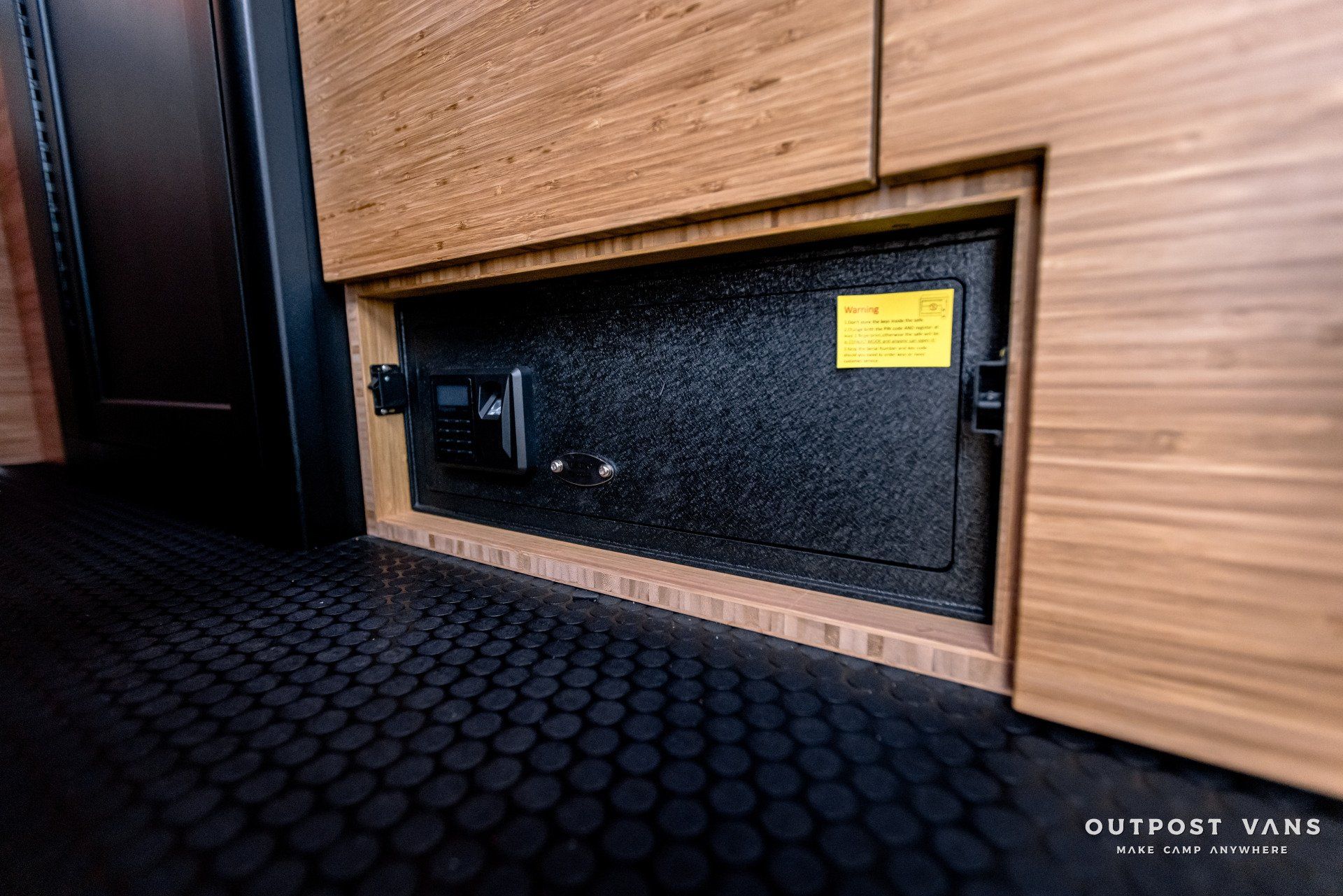 A safe is hidden under a wooden cabinet in a room.
