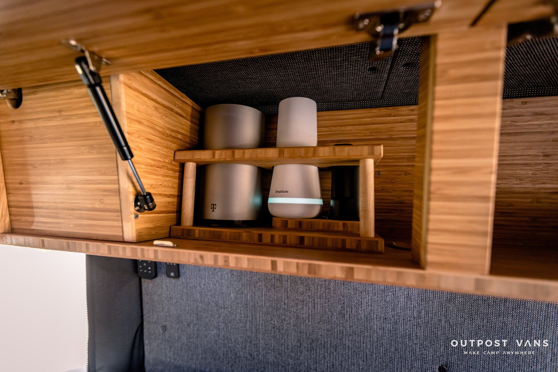 A wooden cabinet with a shelf underneath it with two cups on it.