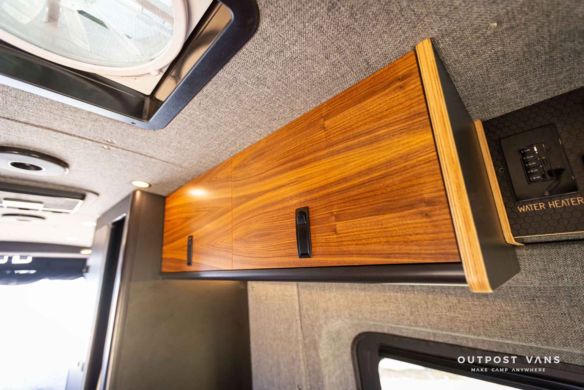 Outpost Vans custom built camper van Ford Transit 148 AWD. A van with wooden cabinets and a fan on the ceiling.