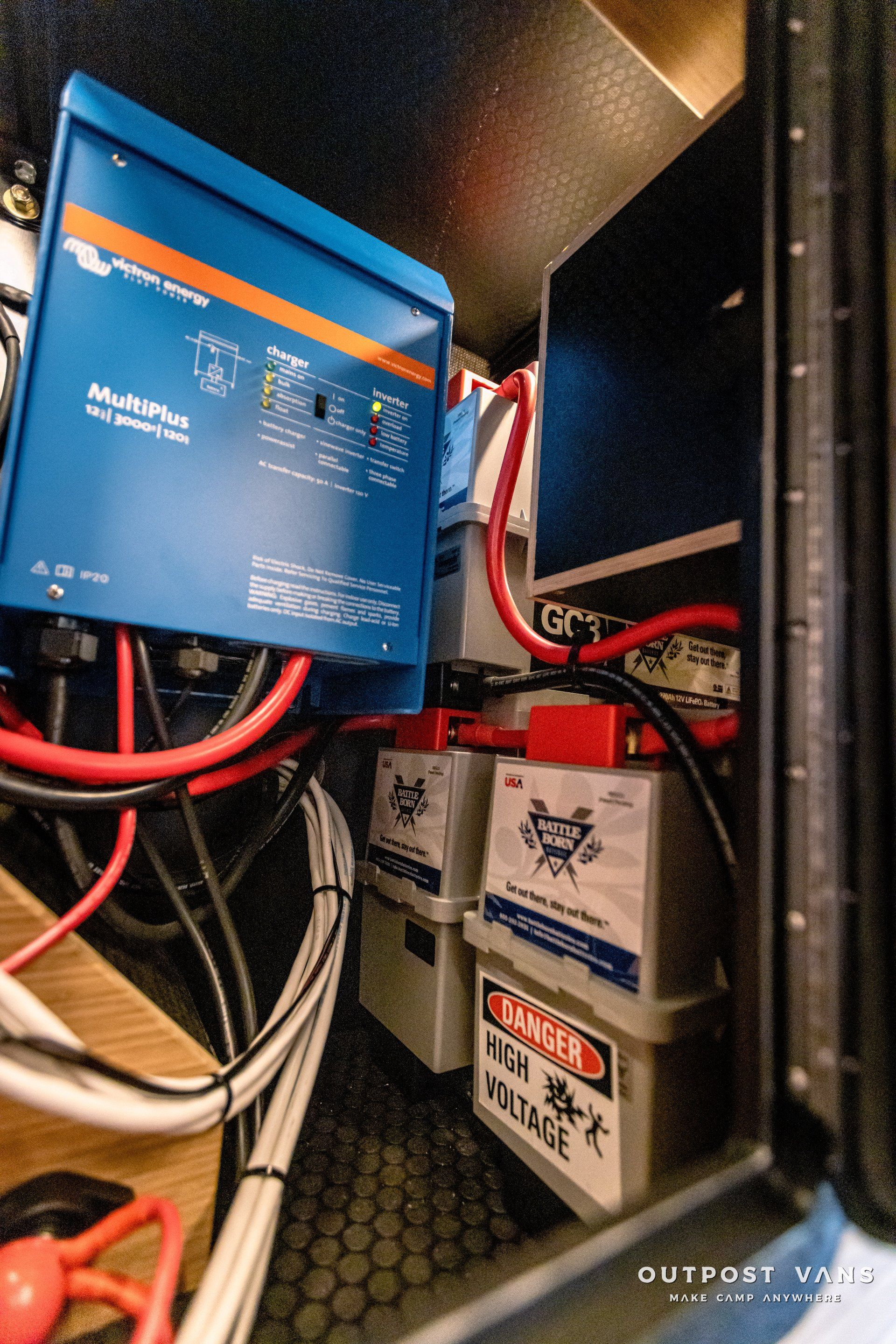 A bunch of wires are connected to a blue box in a room.