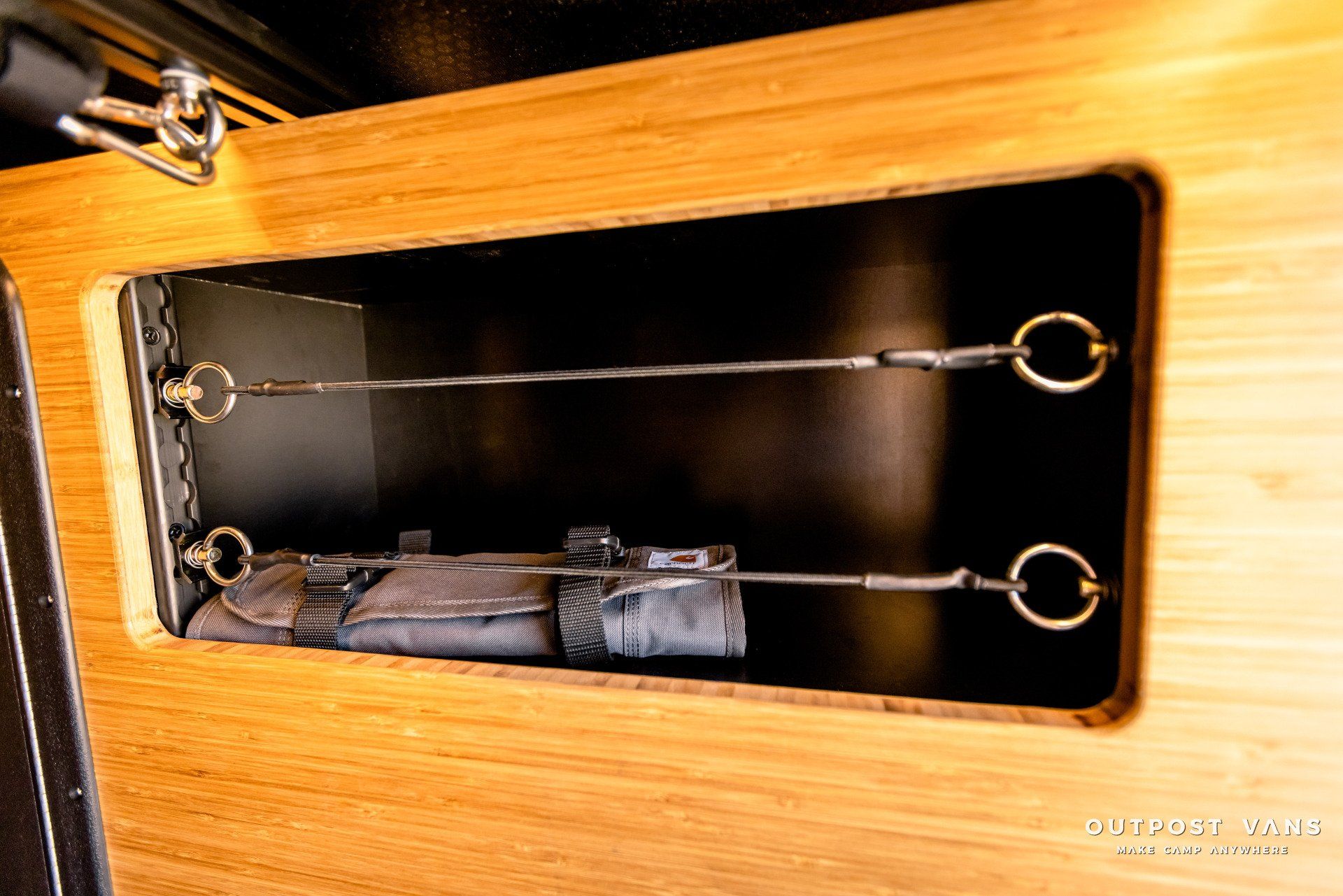 A close up of a wooden cabinet with a black door.