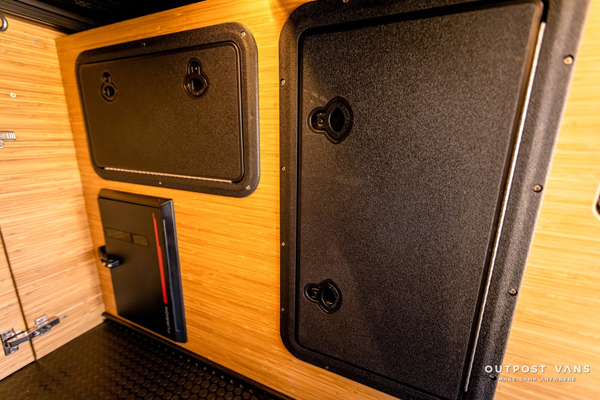 A room with two black doors and a wooden wall.