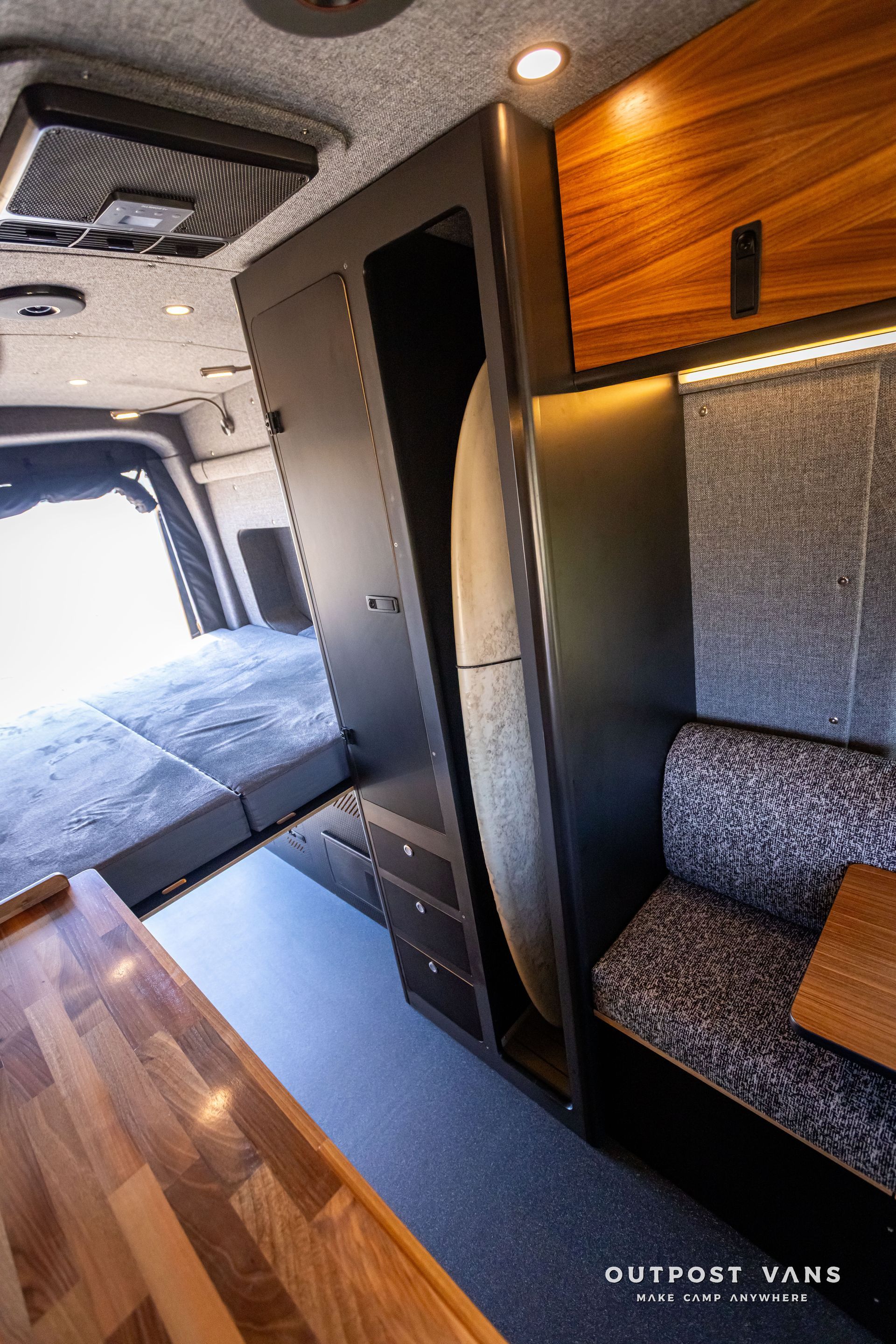 Outpost Vans custom built camper van Ford Transit 148 AWD. The inside of a camper van with custom surfboard closet.