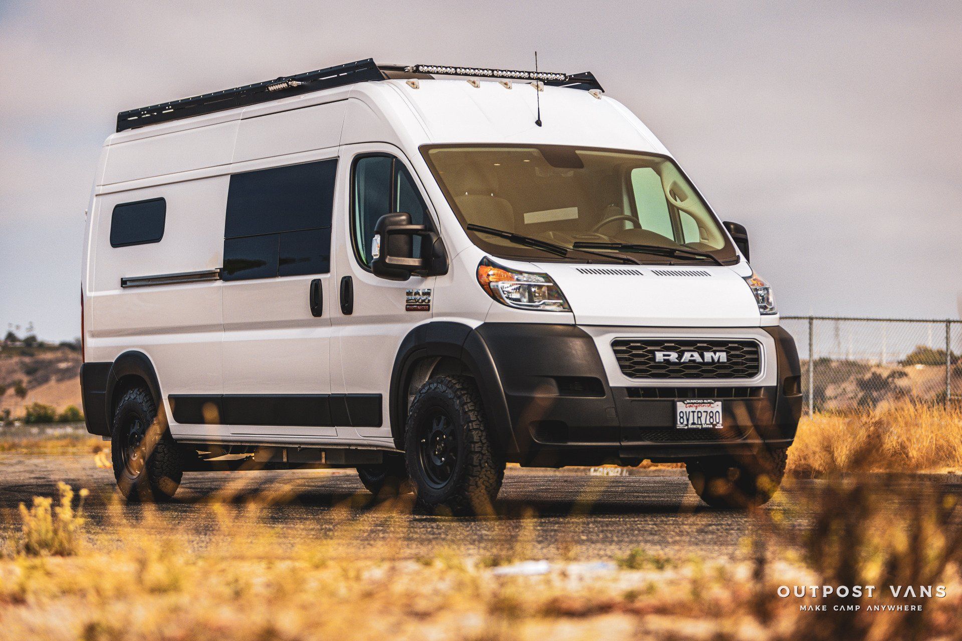 A white van is parked in the middle of a field.