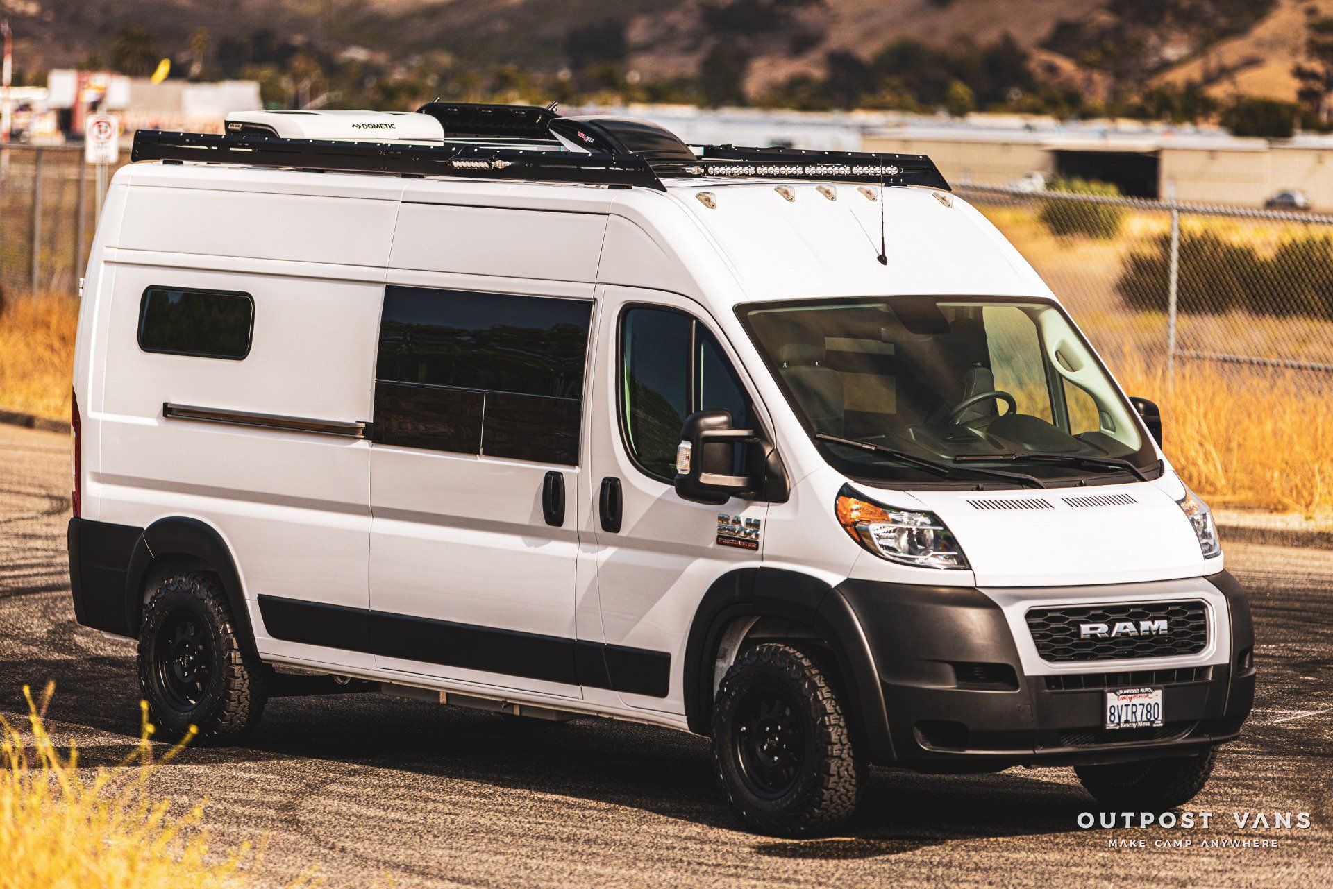 a white van is parked in a dirt field .