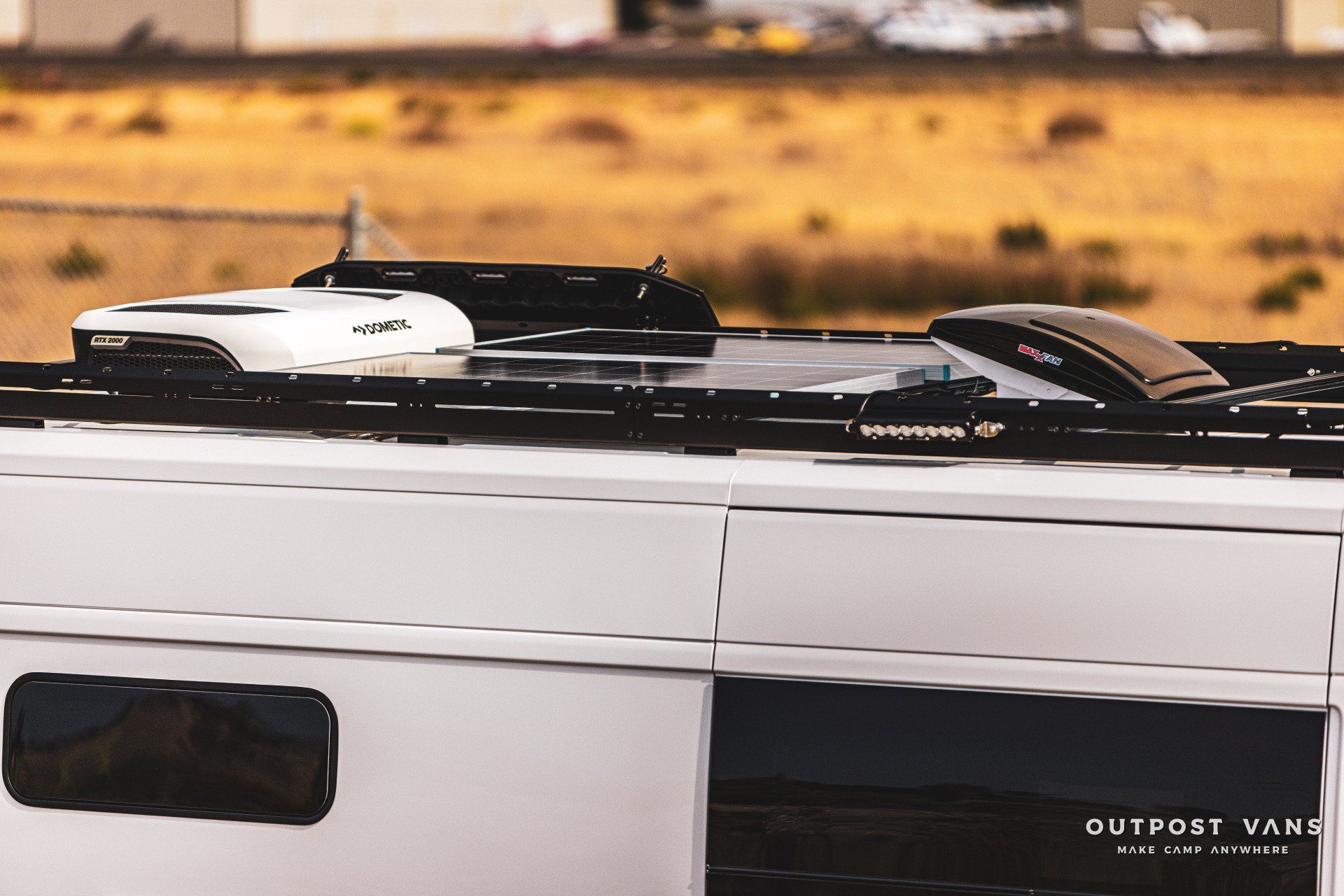 a white outpost van is parked in the desert