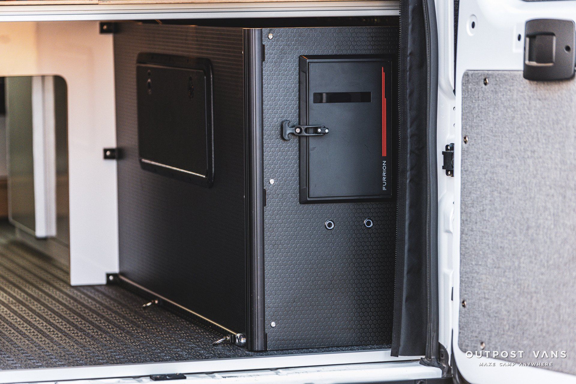 A white van with the door open and a safe in the back