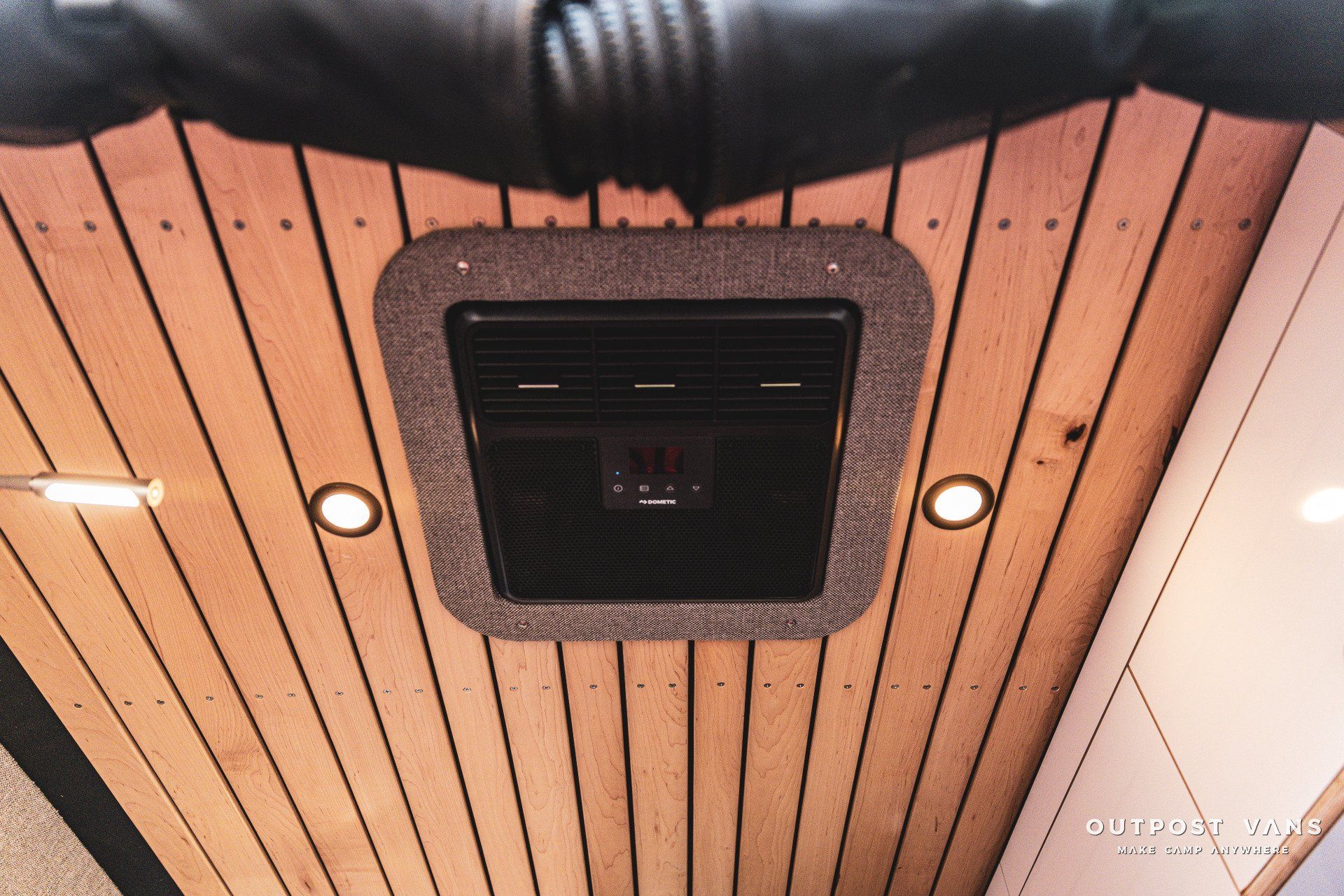 A wooden ceiling with a black box in the middle
