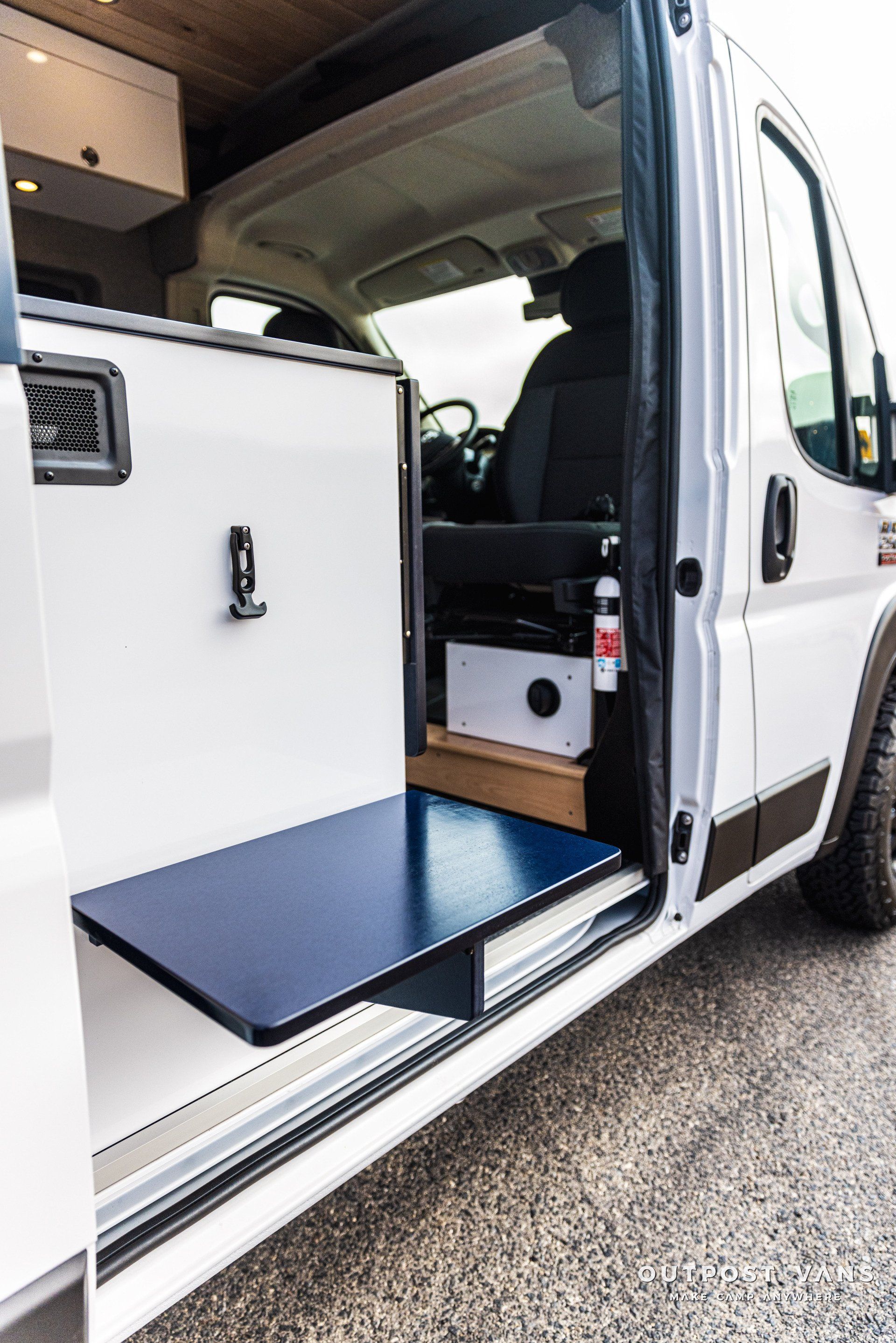 a white van with a blue table in the back of it .