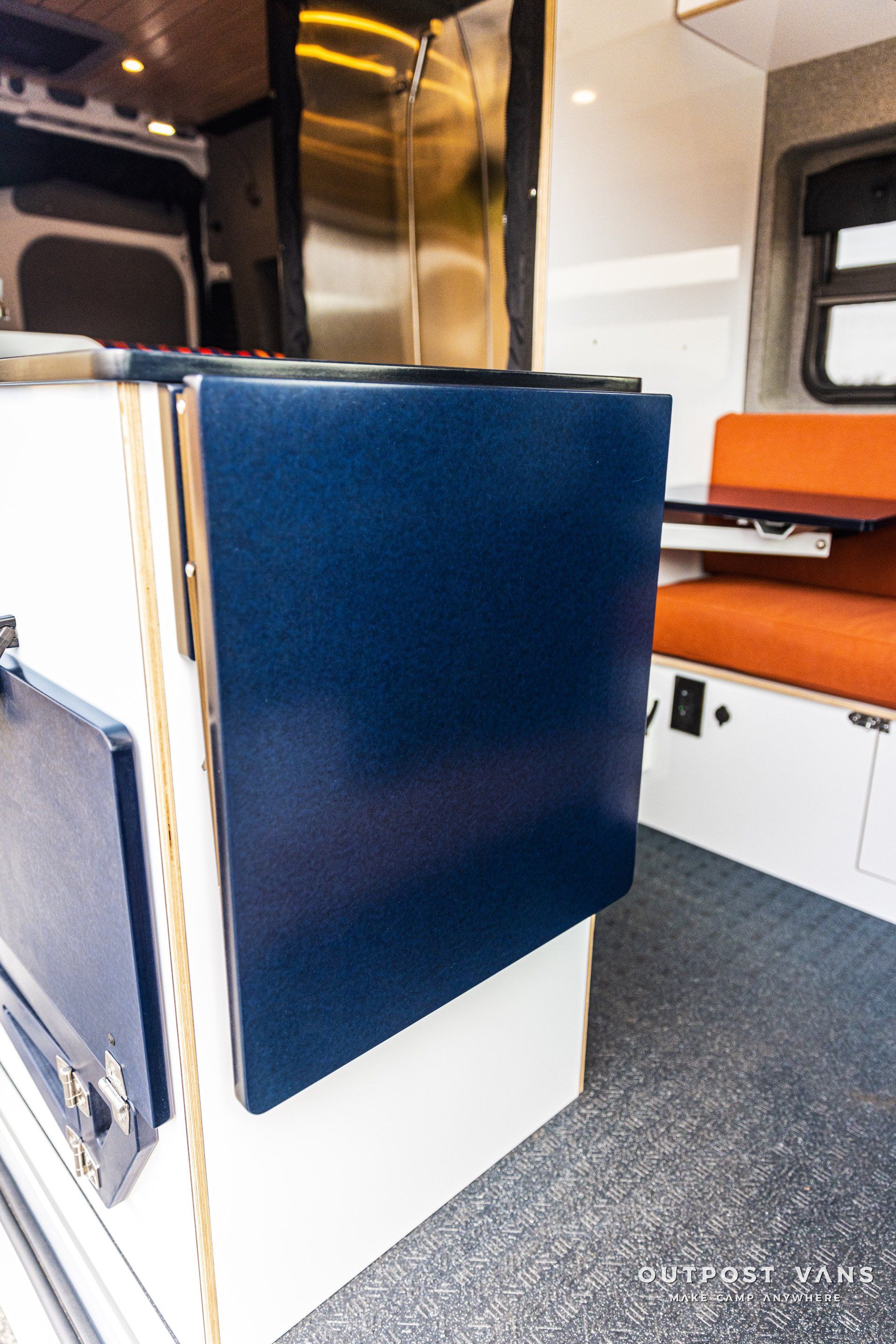 a blue box is sitting on a white shelf in a van .