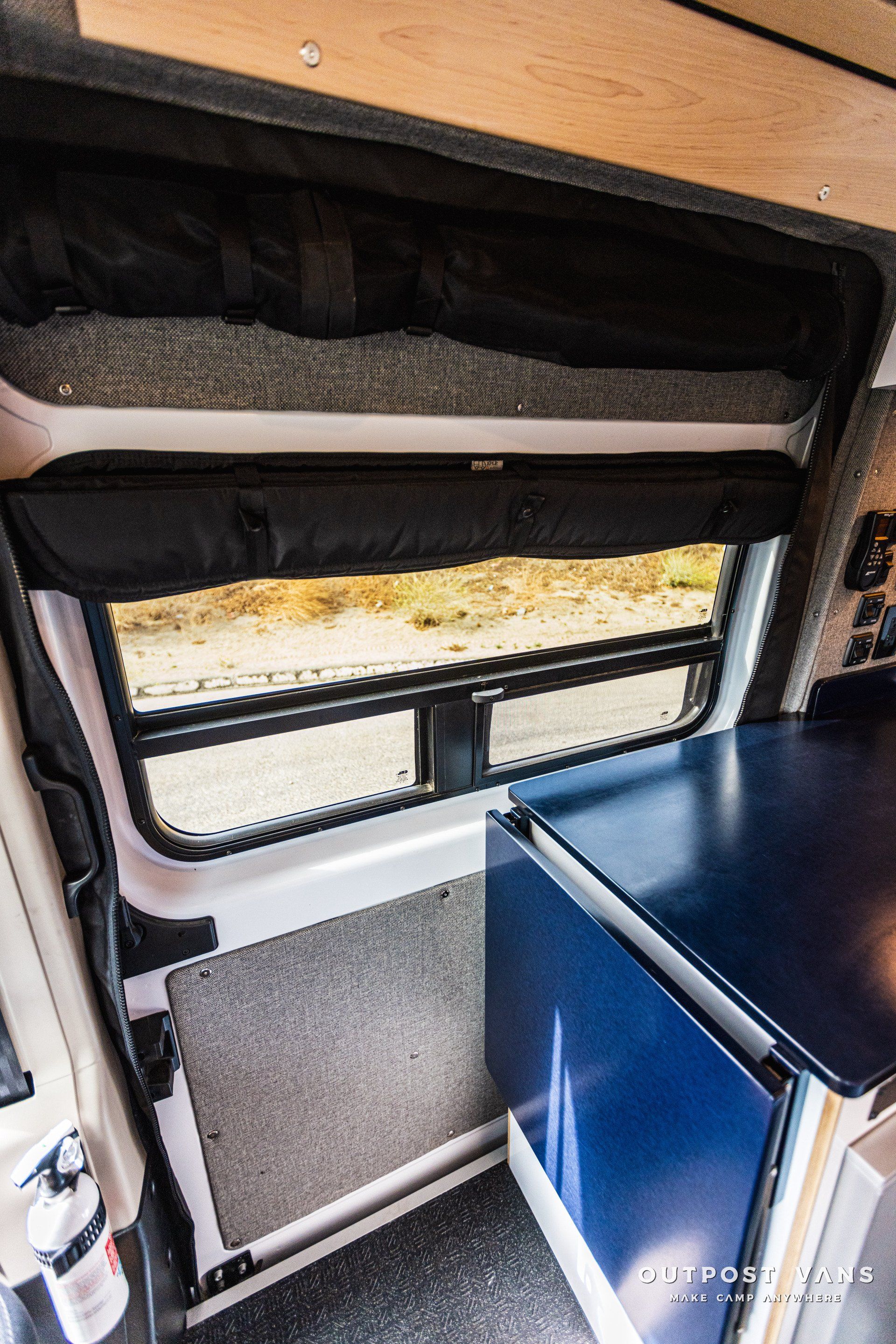 the inside of a van with a fridge and a window .