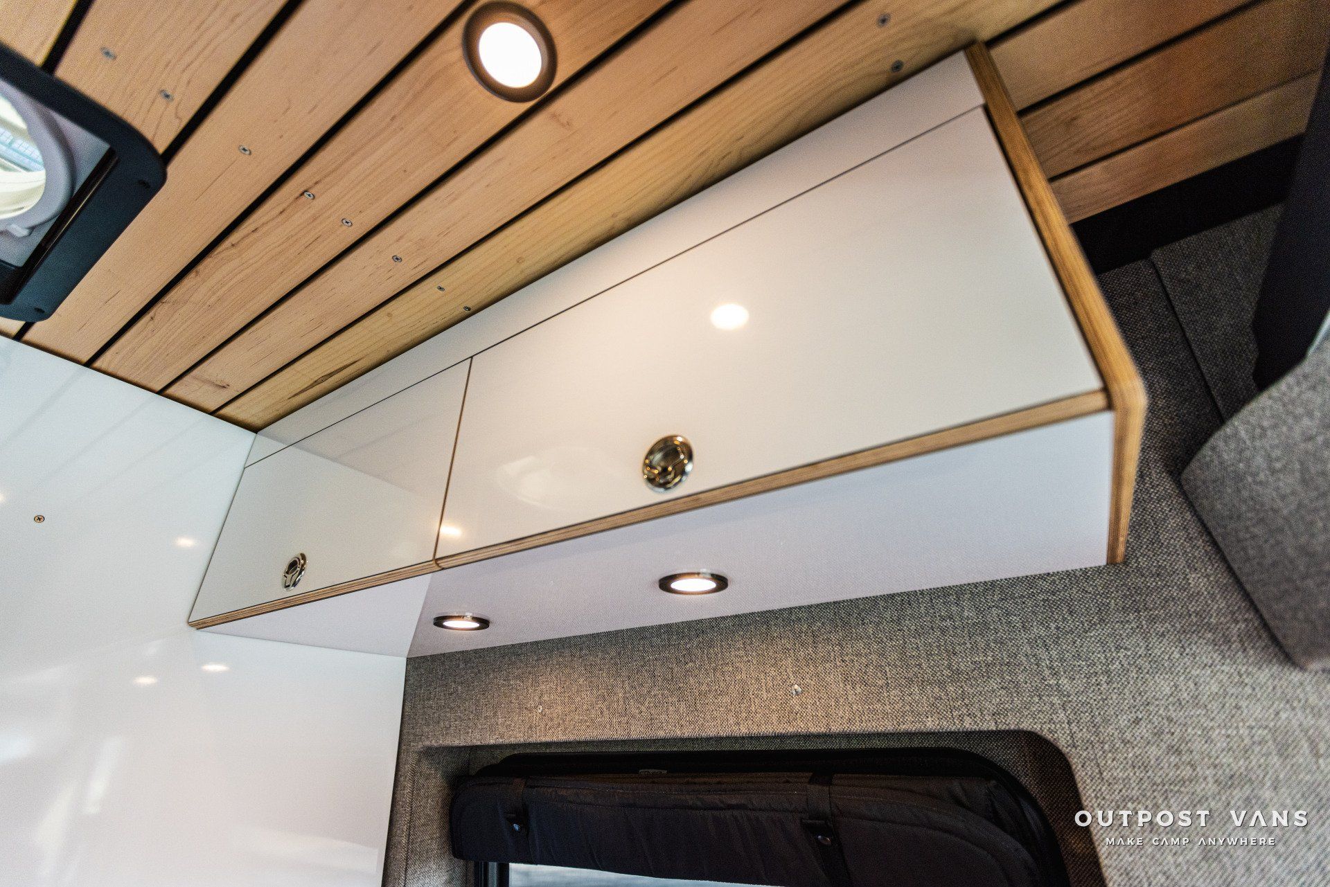 a white cabinet is hanging from the ceiling of a van .