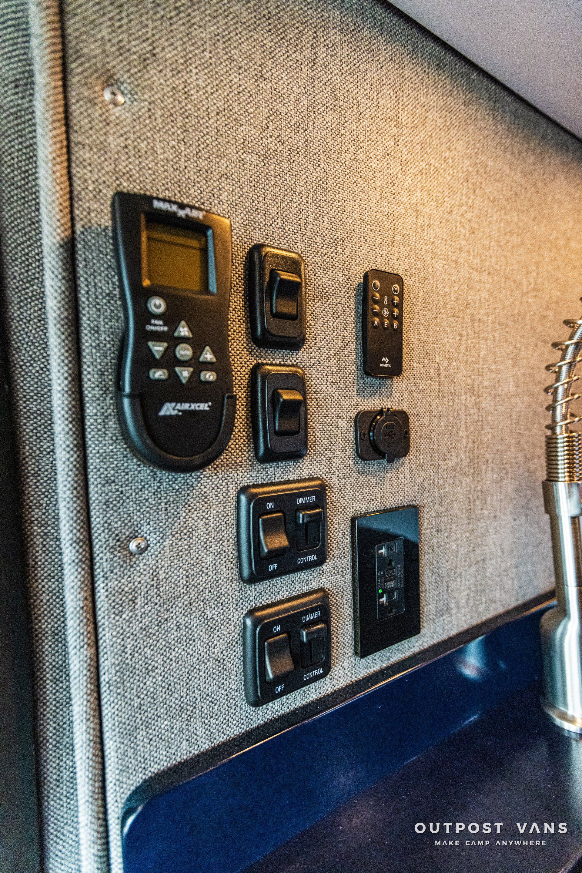 A remote control is sitting on a wall next to a sink.