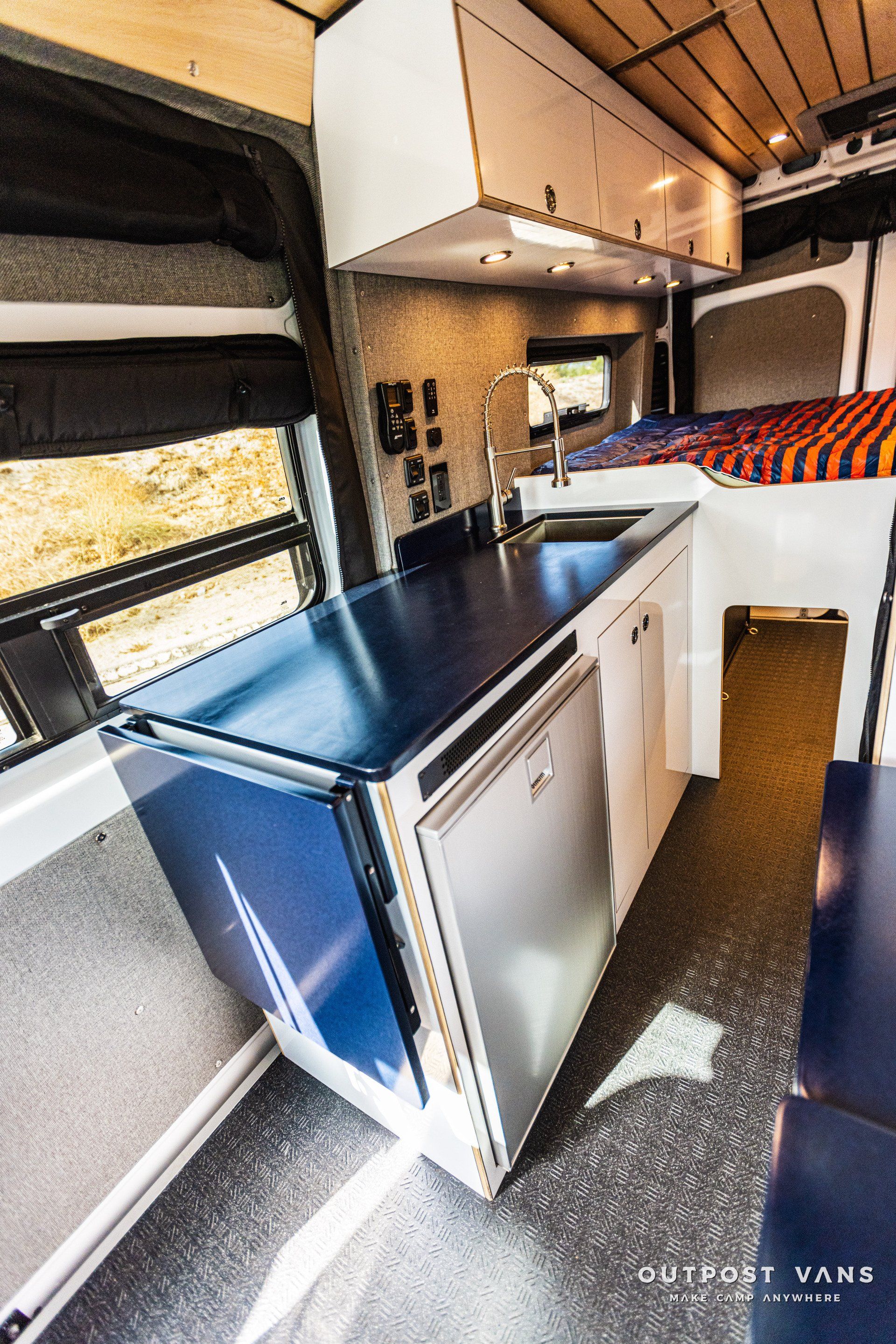 A kitchen in a van with a blue counter top and a sink.