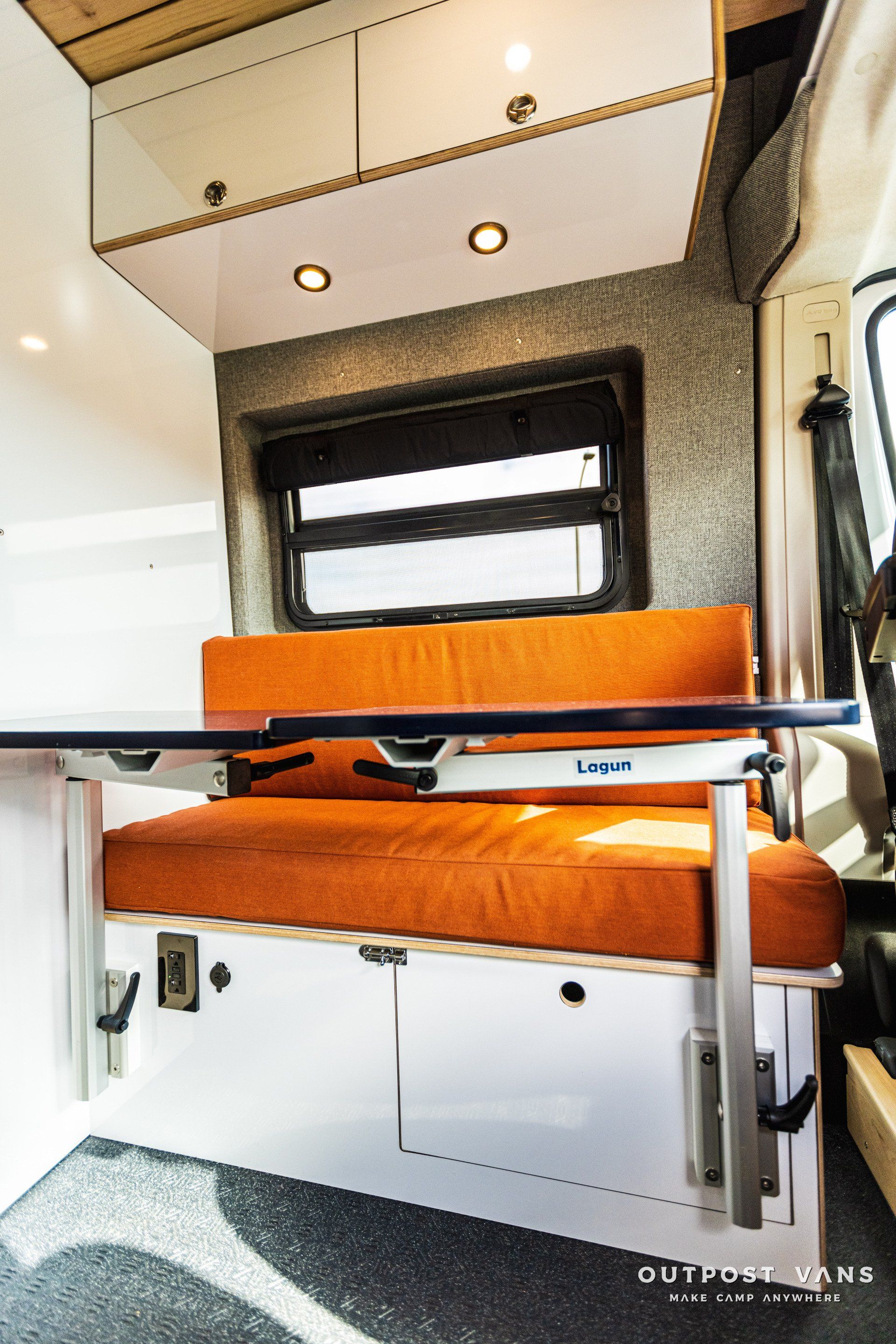 a camper van with an orange couch and a table