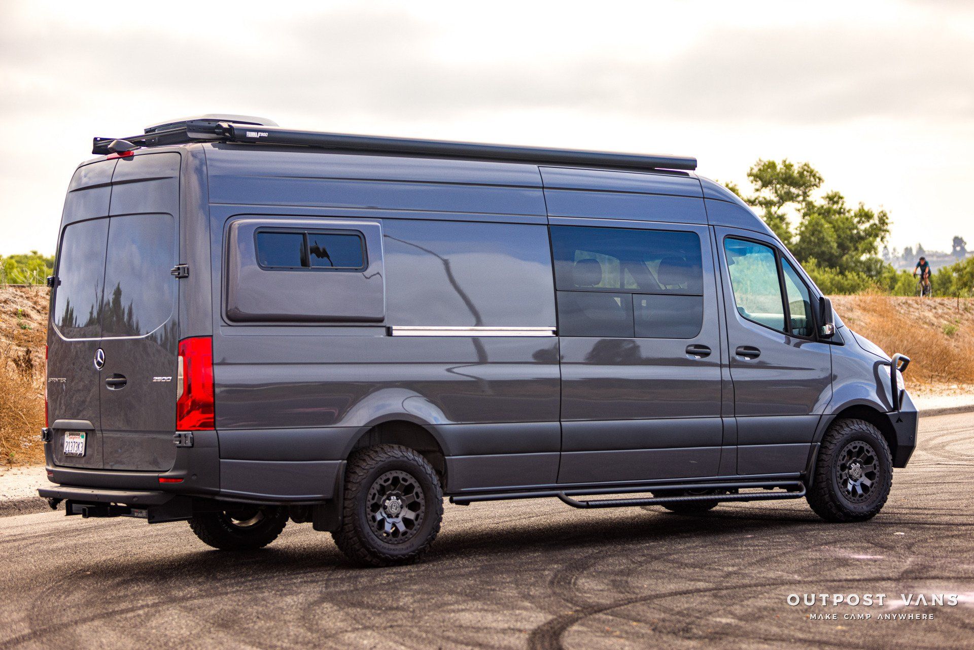 A black van is parked on the side of the road.