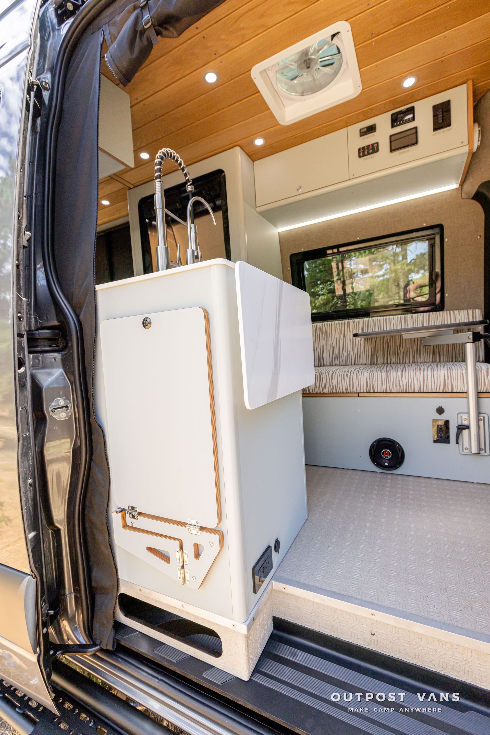 There is a sink in the back of a van. Outpost vans Sprinter 170 AWD.