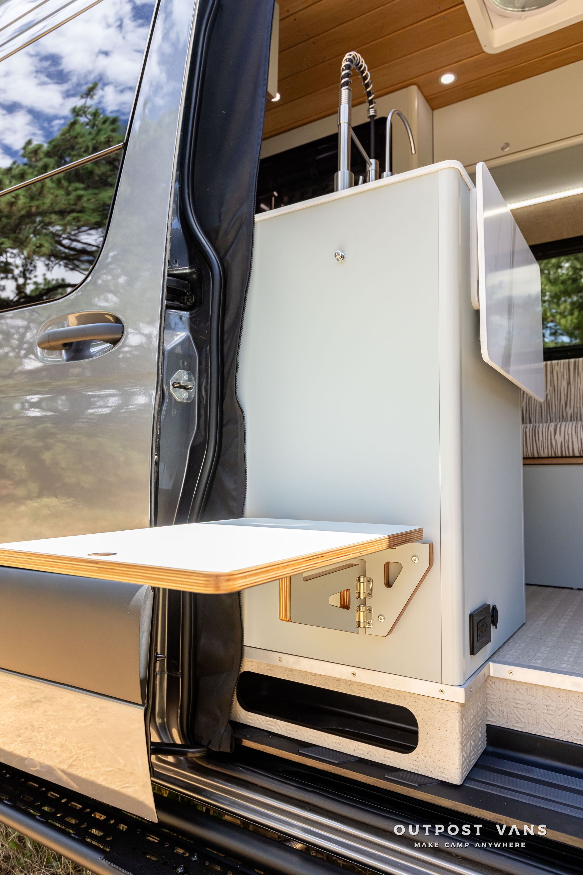 A van with a sink and a table in the back. Outpost vans Sprinter 170 AWD.