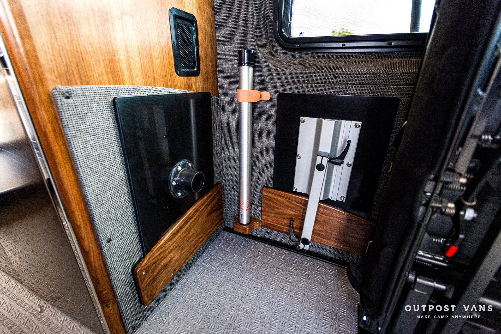 A corner of a camper van with a table and a window.