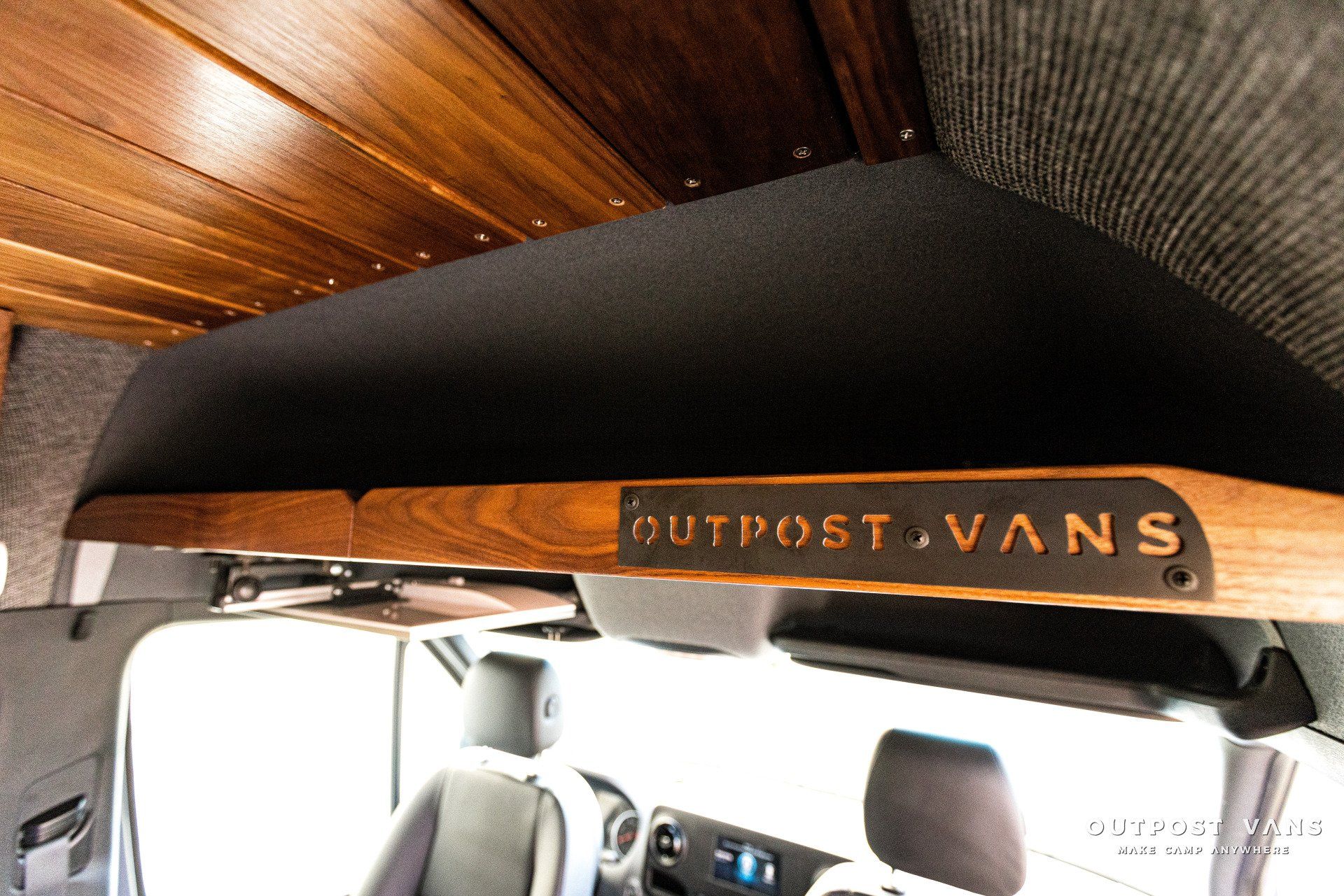 A wooden shelf with outpost vans written on it