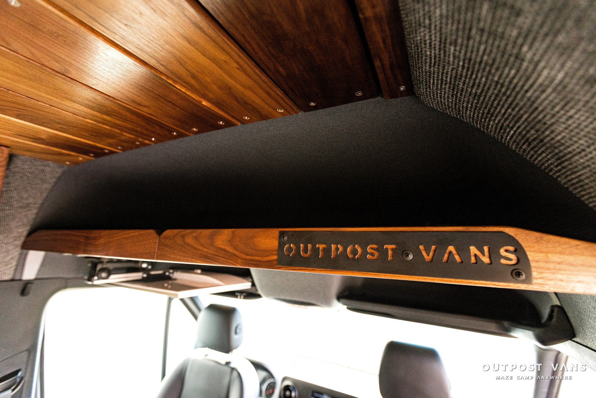 A wooden shelf with outpost vans written on it