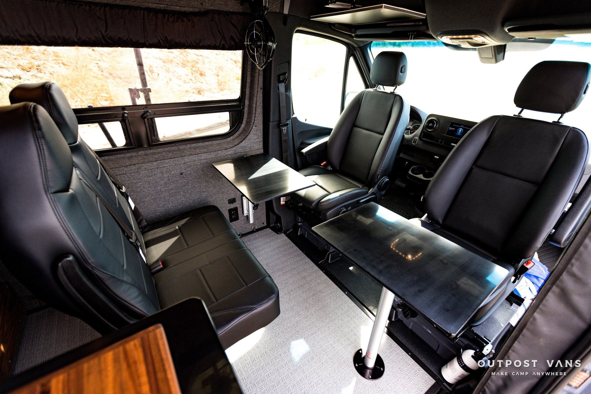 The inside of a van with black seats and a table