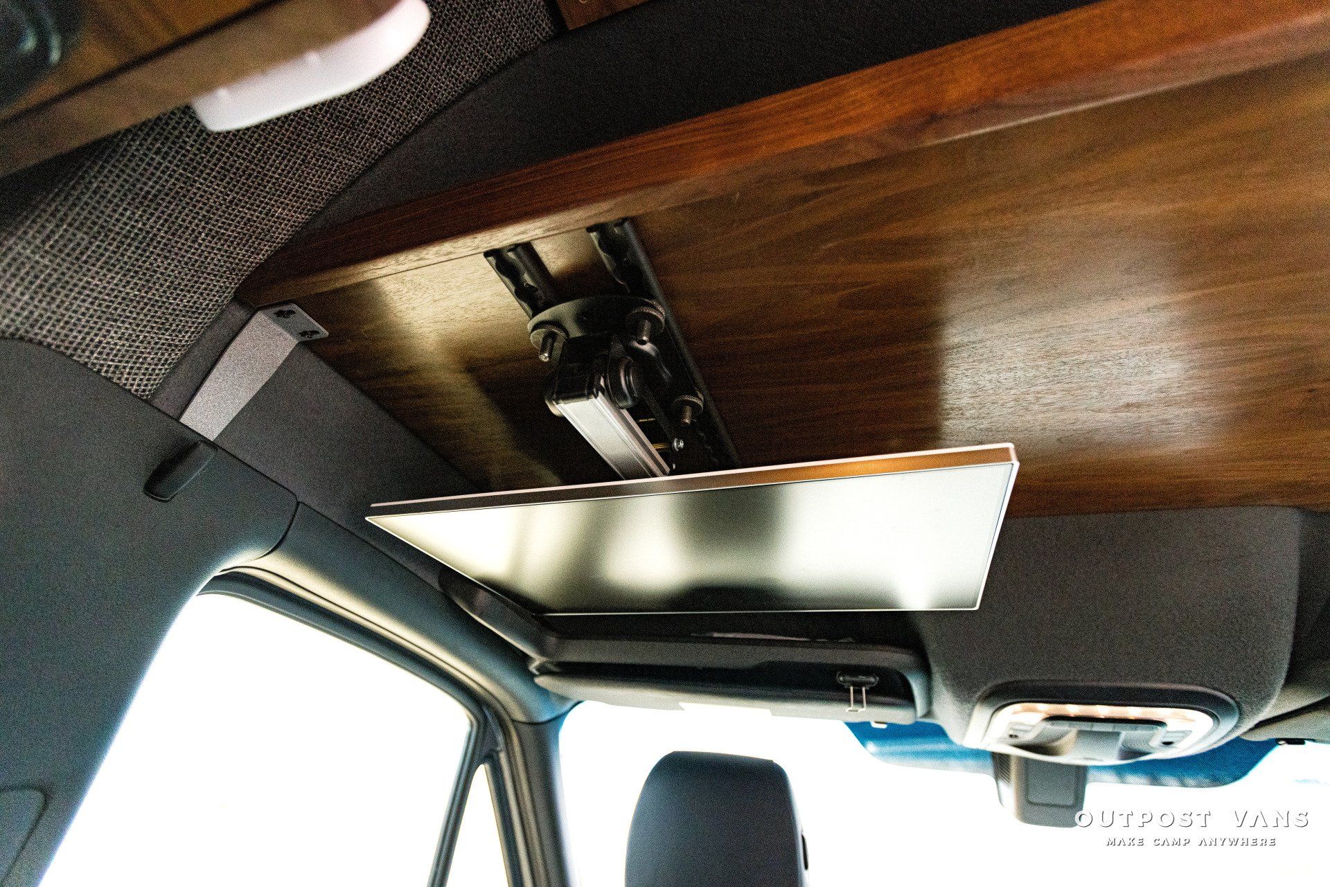 A tv mounted to the ceiling of a car.
