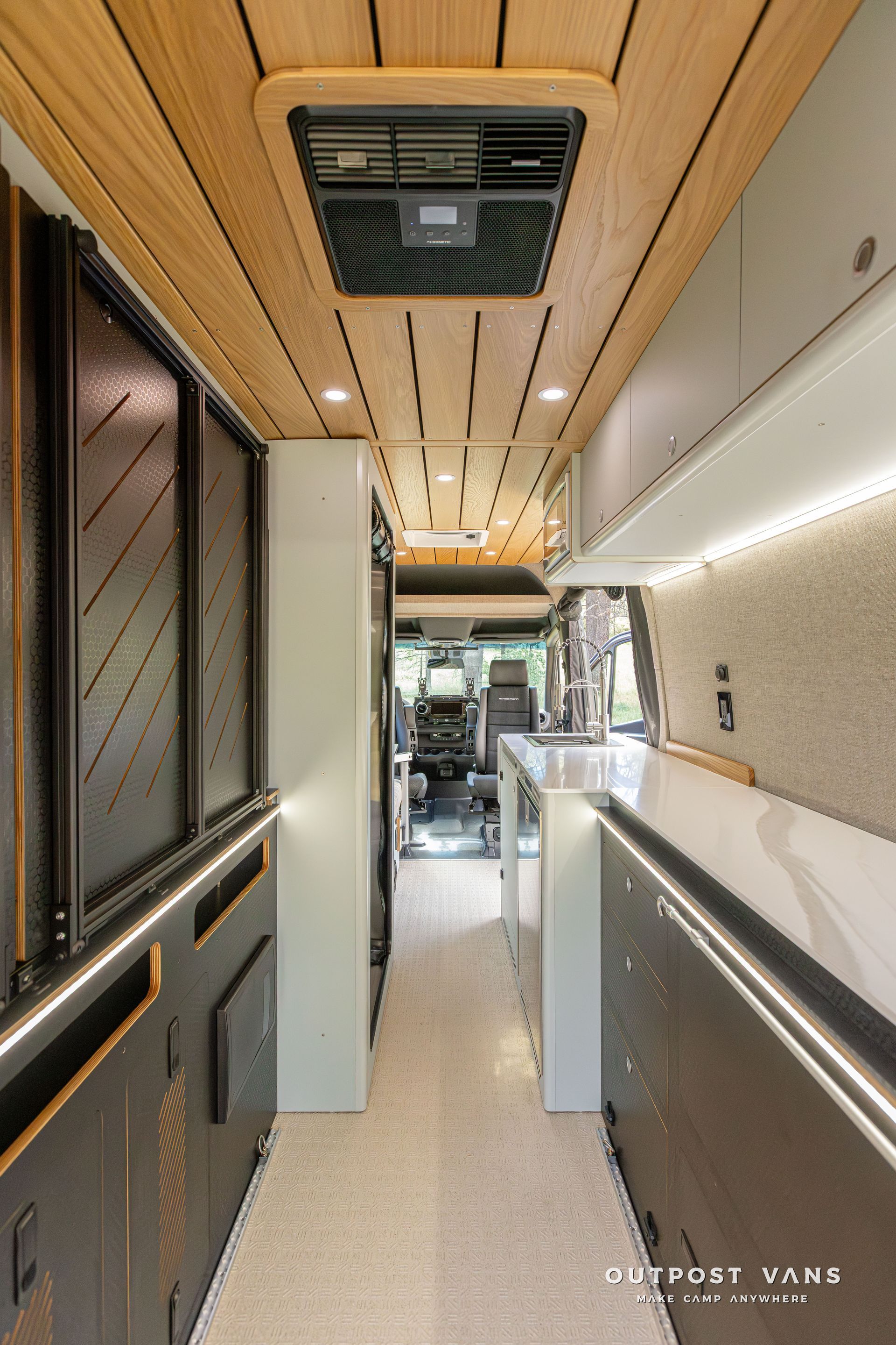 A long hallway leading to a kitchen in a camper van. Outpost vans Sprinter 170 AWD.