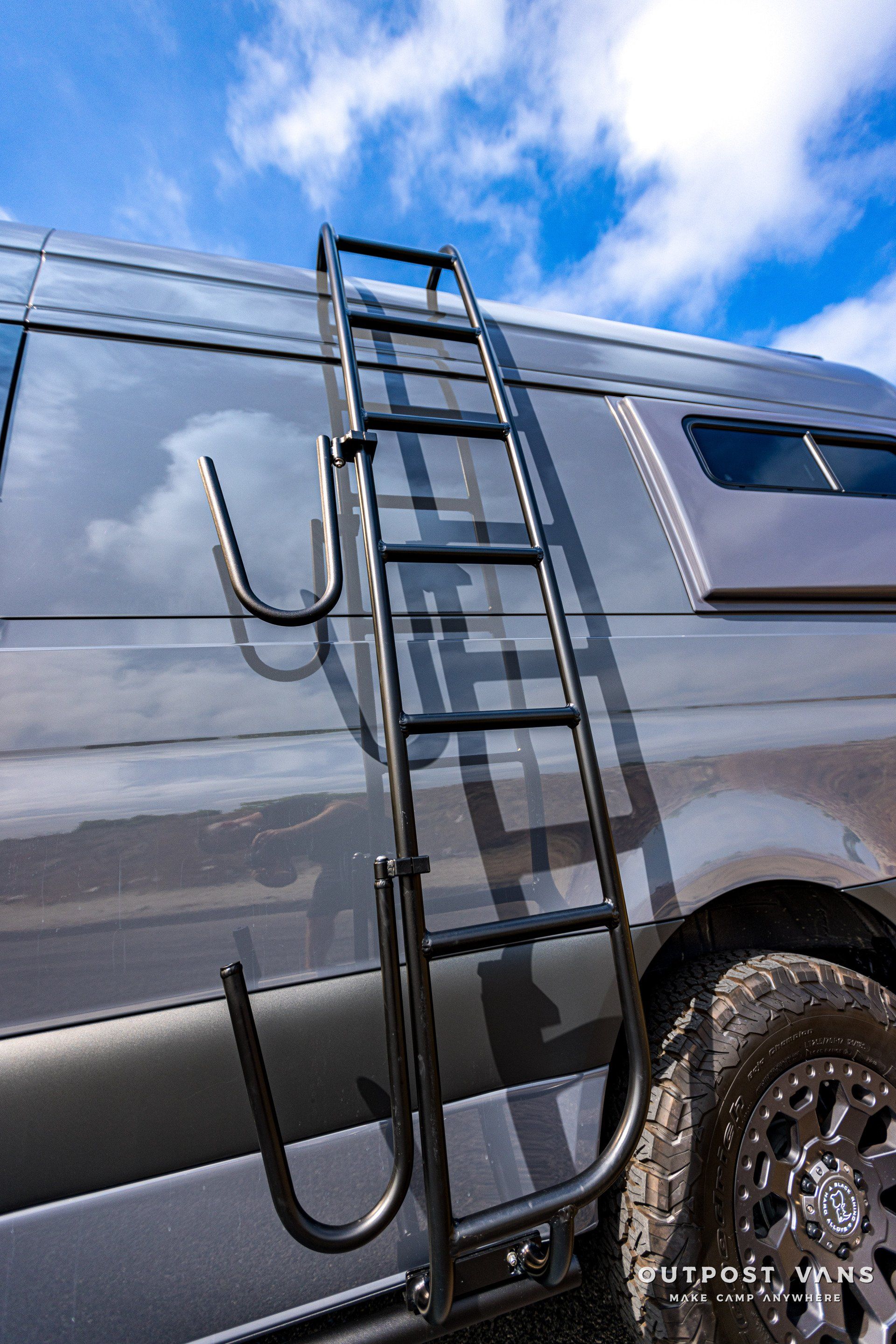 A ladder is attached to the side of a van.