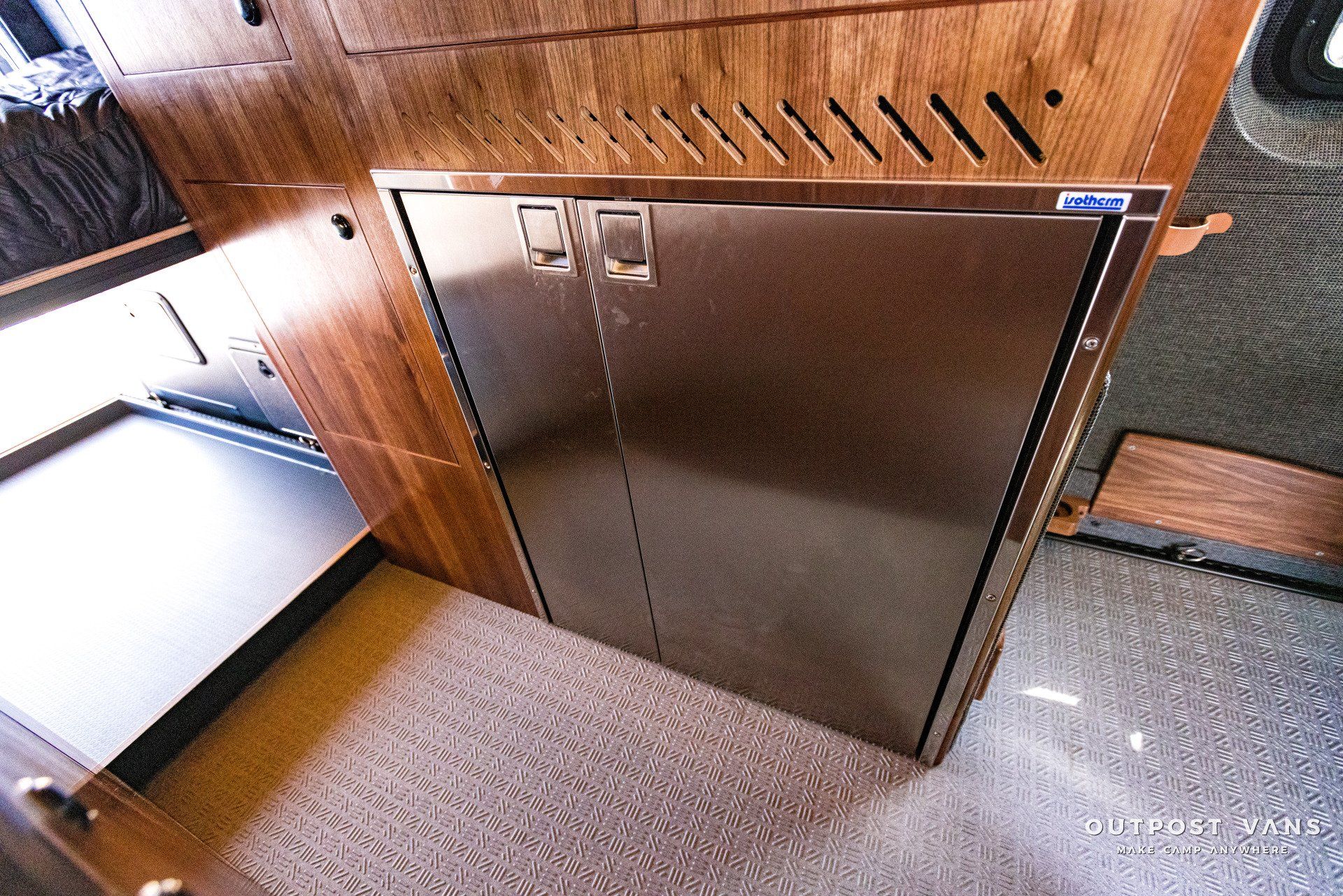 A stainless steel refrigerator is in a room with wooden cabinets.