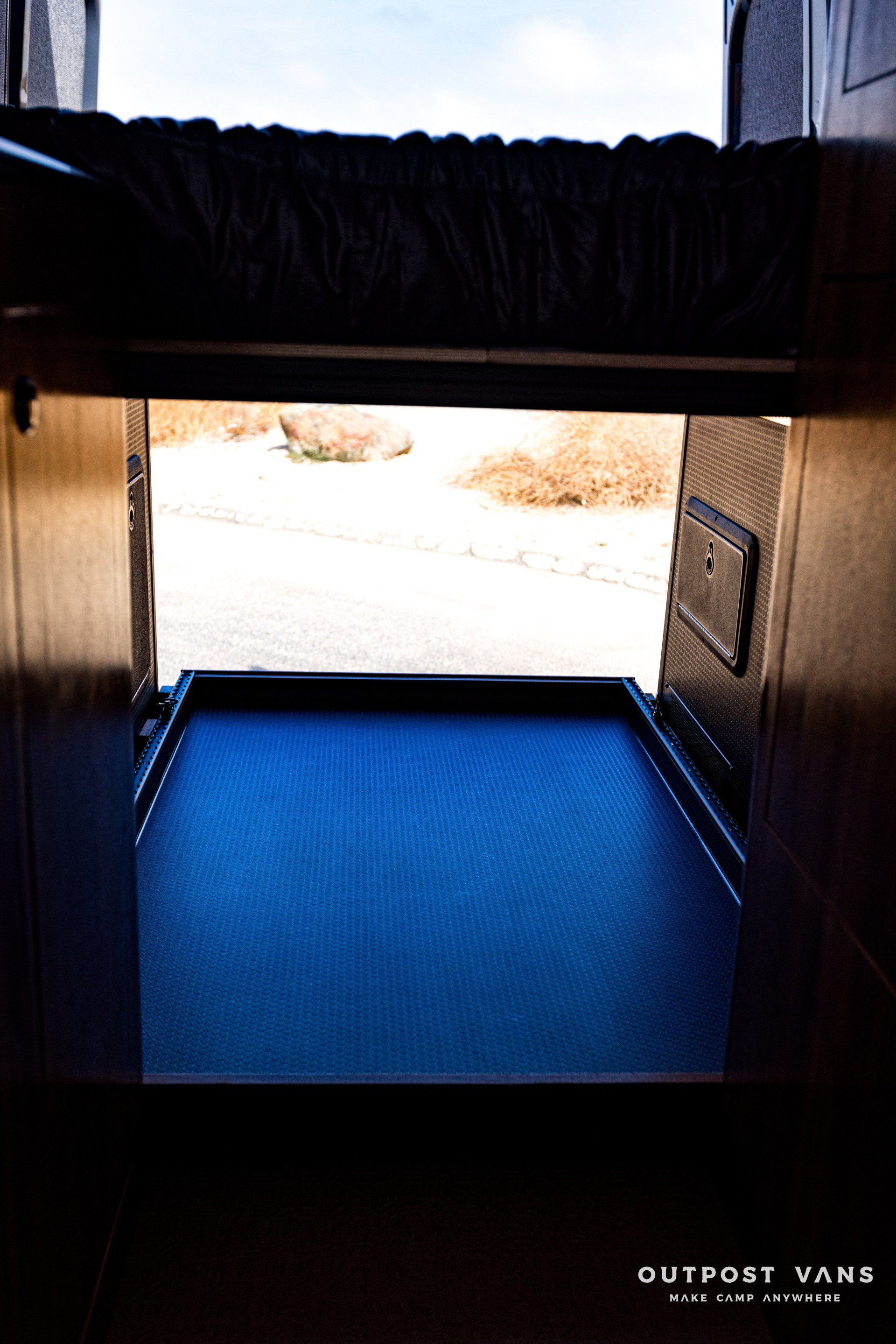 A picture of the inside of a van with a blue floor