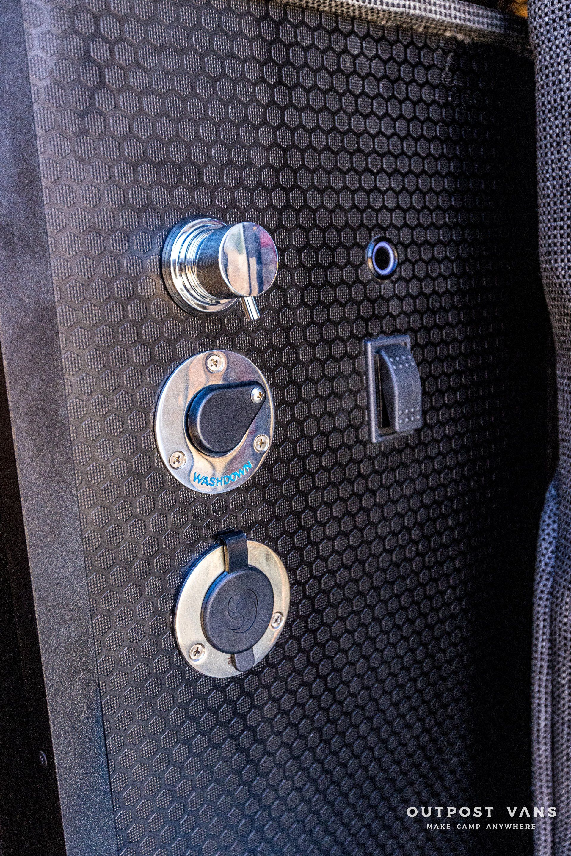 A close up of a black wall with a bunch of buttons on it.