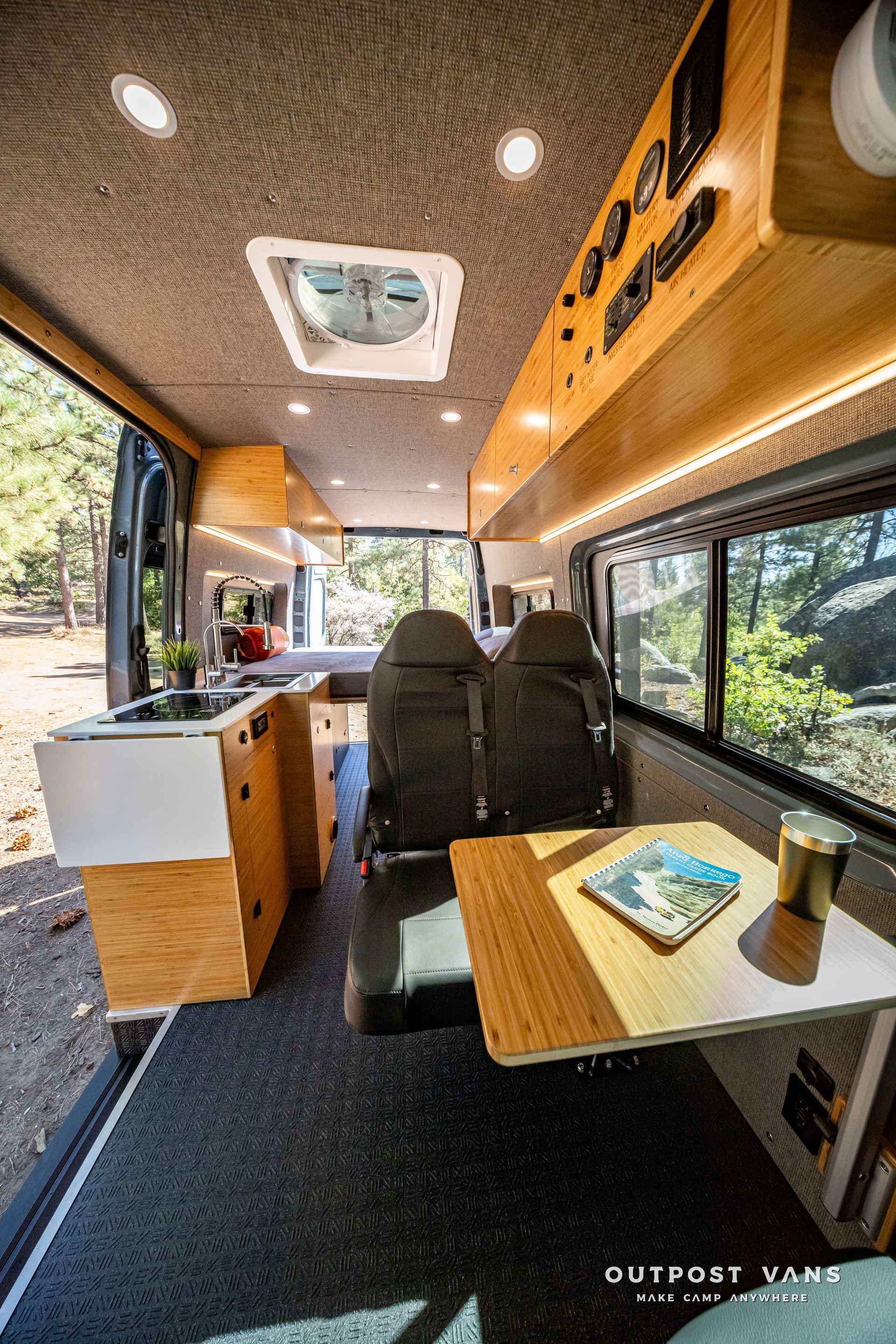 Sprinter Interior of a van converted into a camper, with kitchen, seating, and overhead lights.