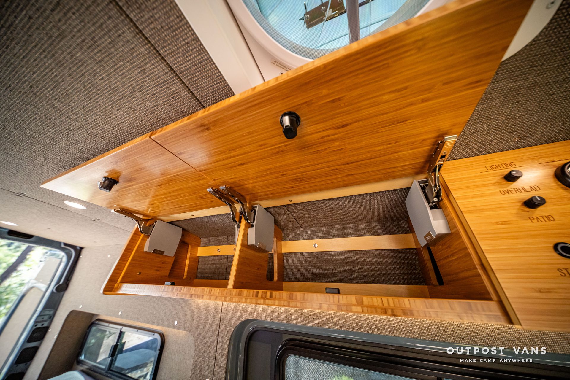 Sprinter Interior view of a camper van with bamboo cabinetry and a ceiling vent.
