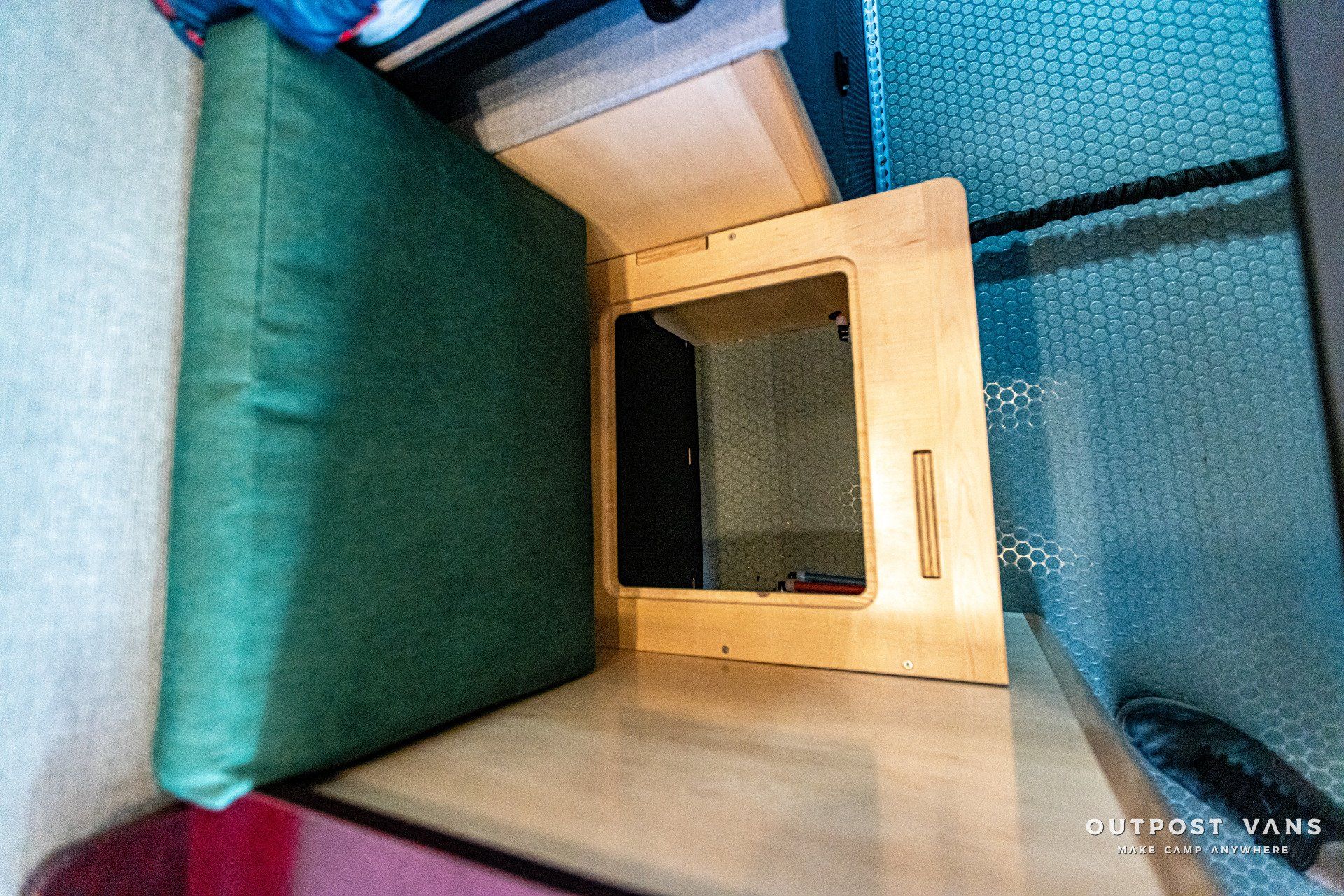 A green cushion is sitting on top of a wooden table.