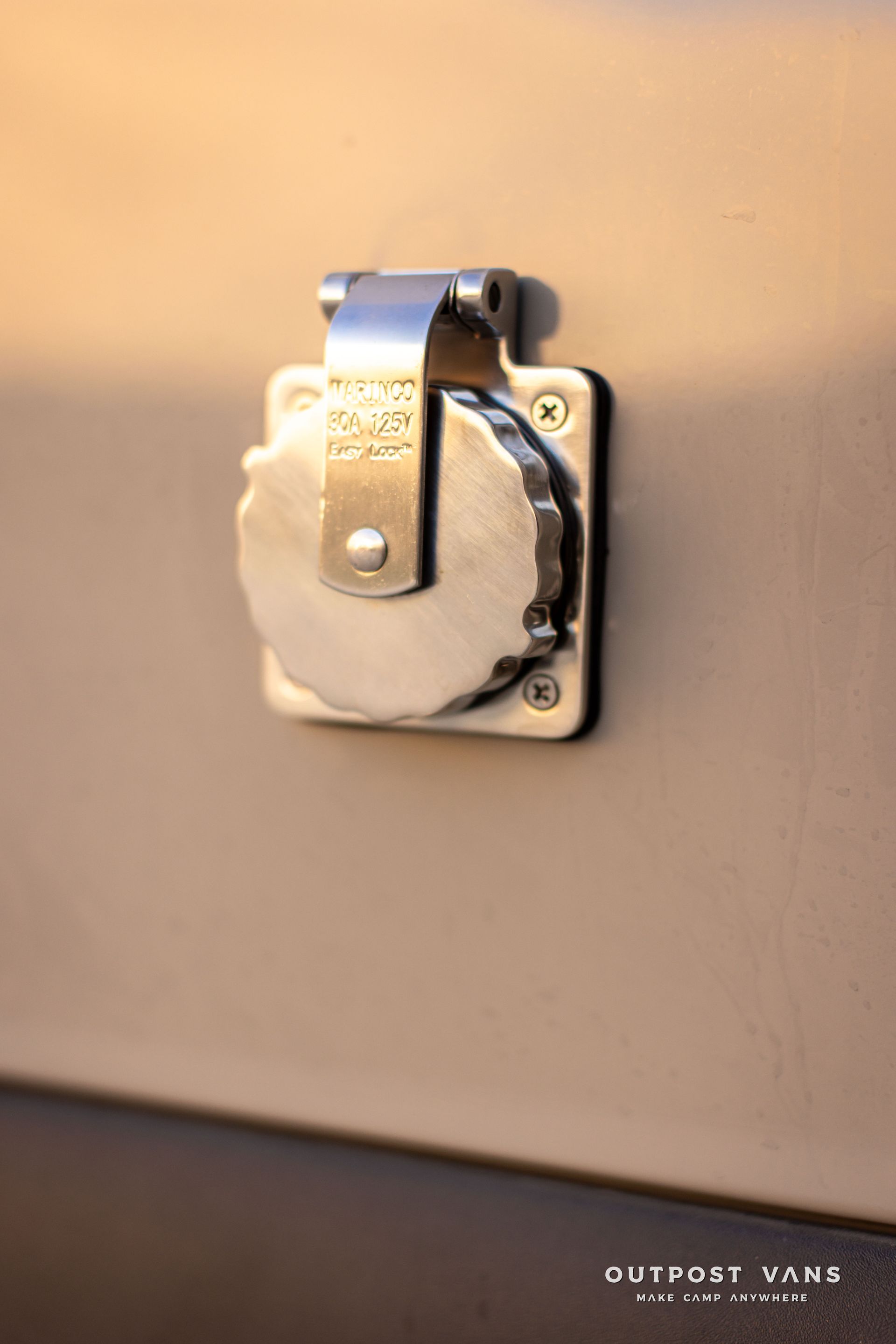 White plaster hand holding a metal door latch on a beige wall