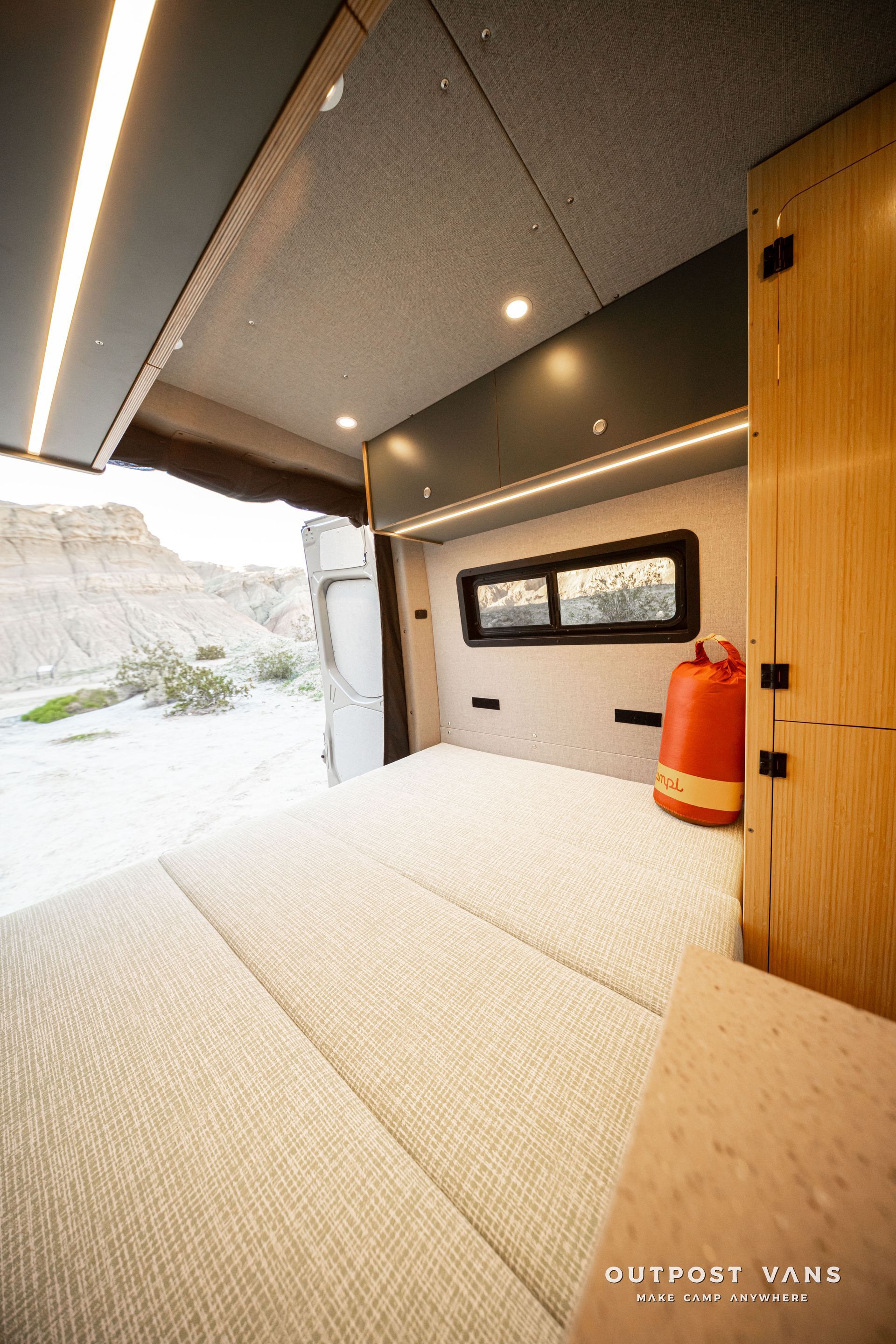 Modern minimalist interior with tatami mats, a wall mirror, and a red fire extinguisher by a wooden door.