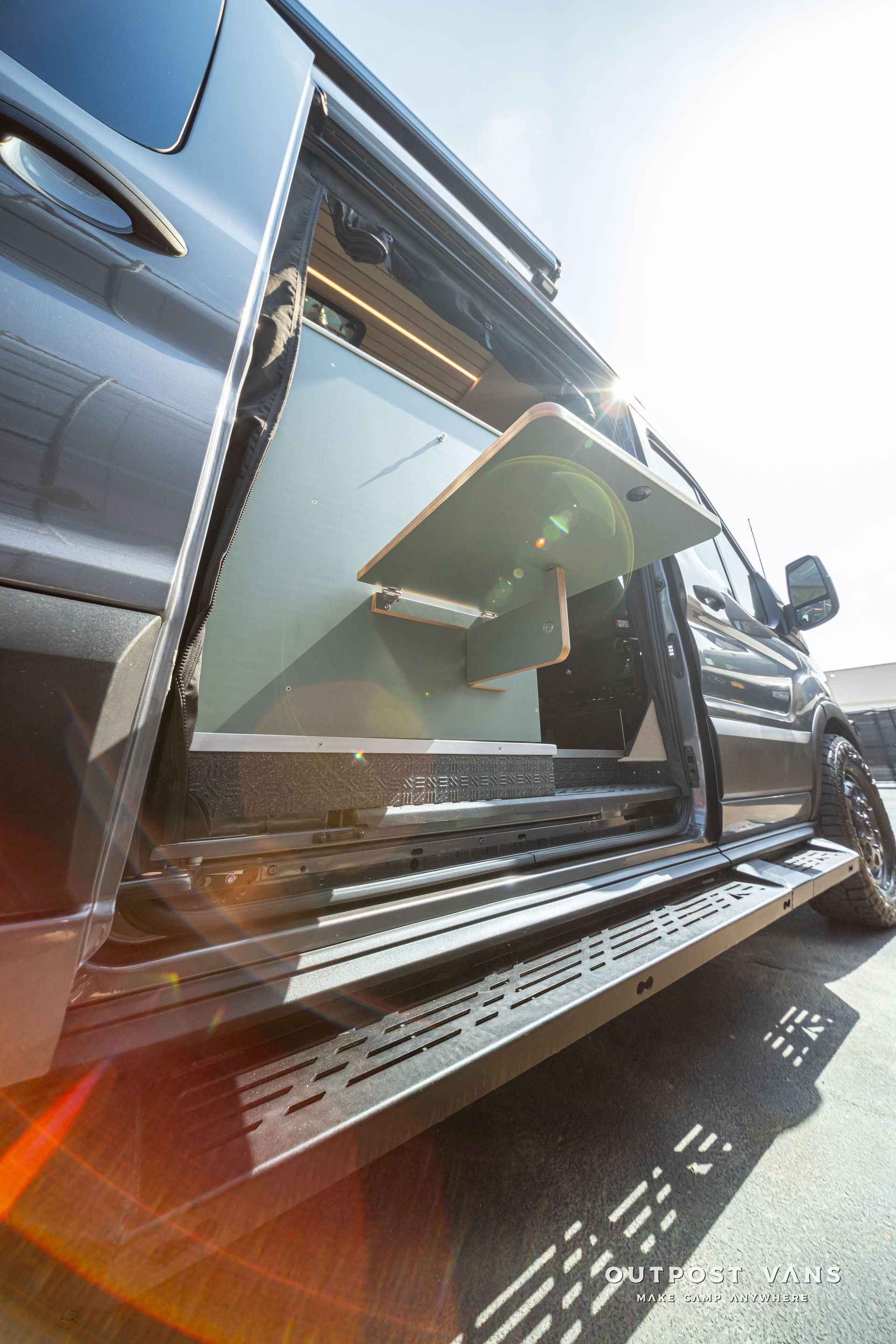 Open truck door with side steps and sun glare, showing the vehicle’s interior.