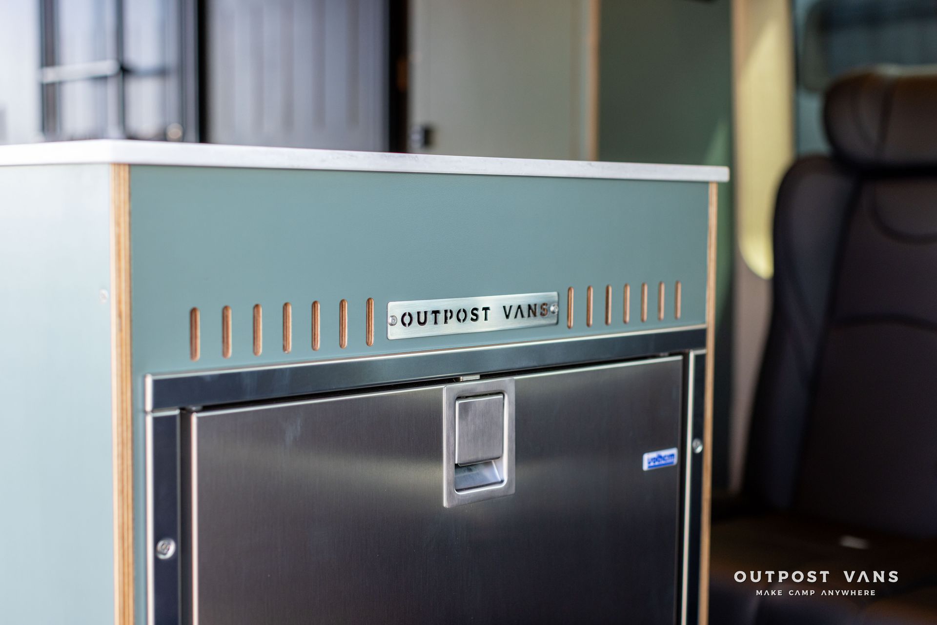 Teal stainless steel mini fridge in a modern kitchen corner