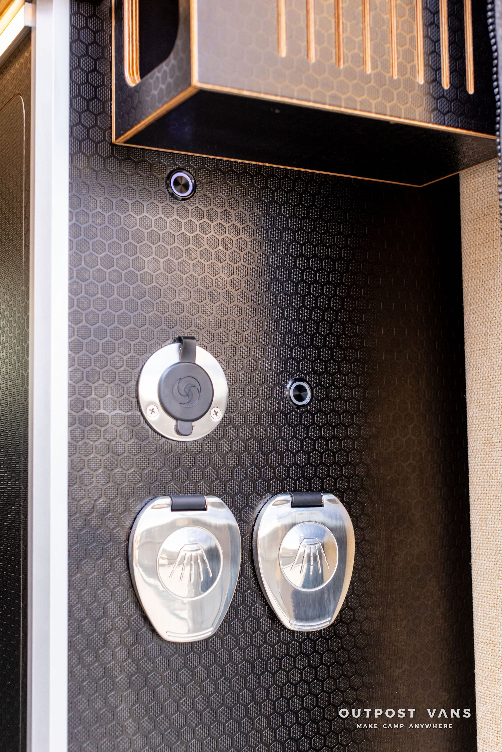 Intercom panel with two silver doorbells on a textured dark wall beneath a mailbox flap