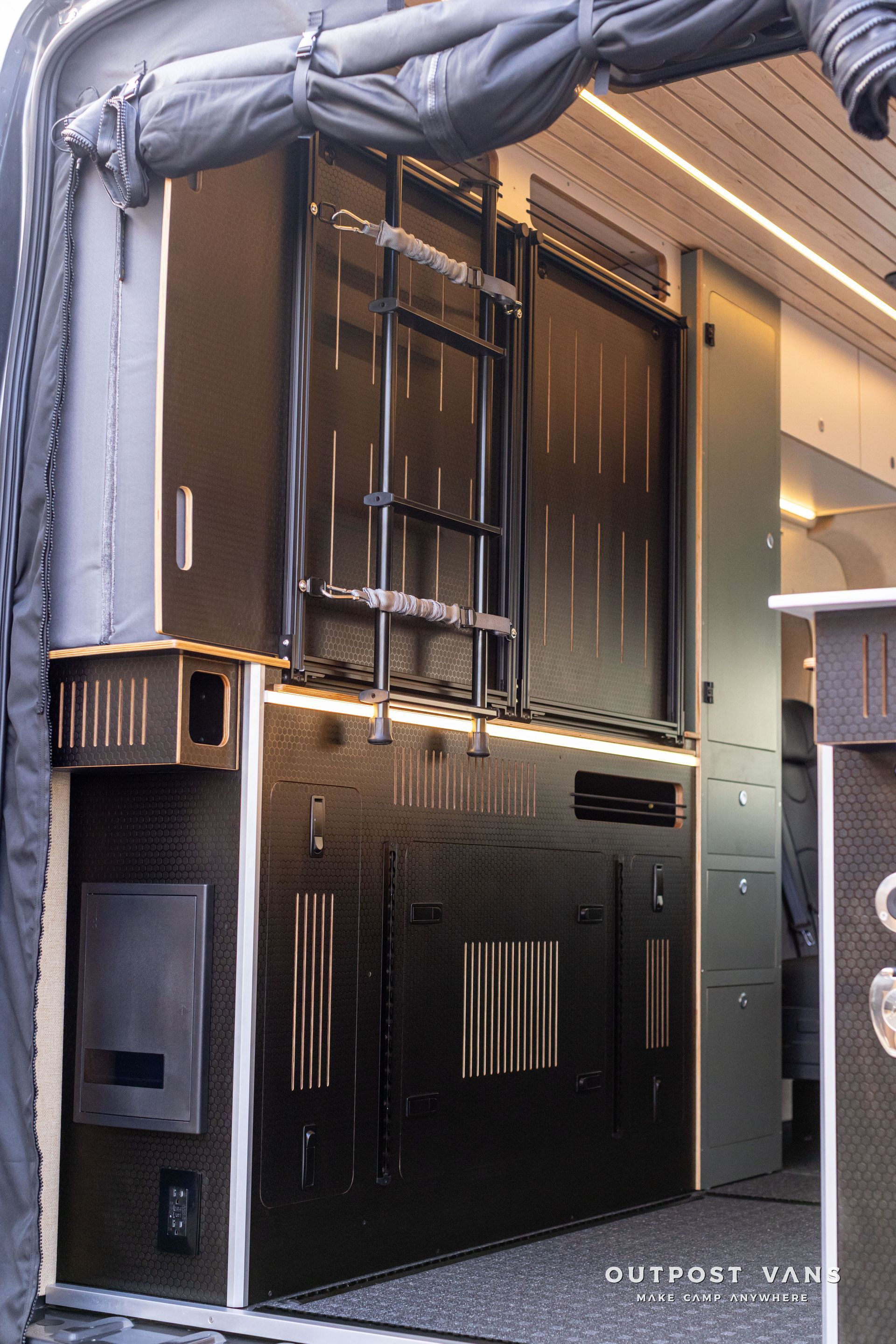 Large black industrial cabinet or equipment unit in a covered outdoor/garage space