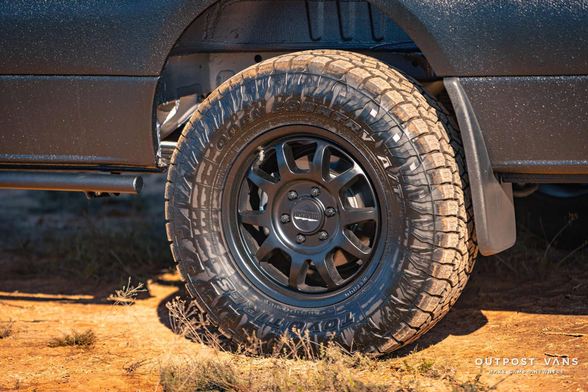 a close up of a tire on a truck on a dirt road .