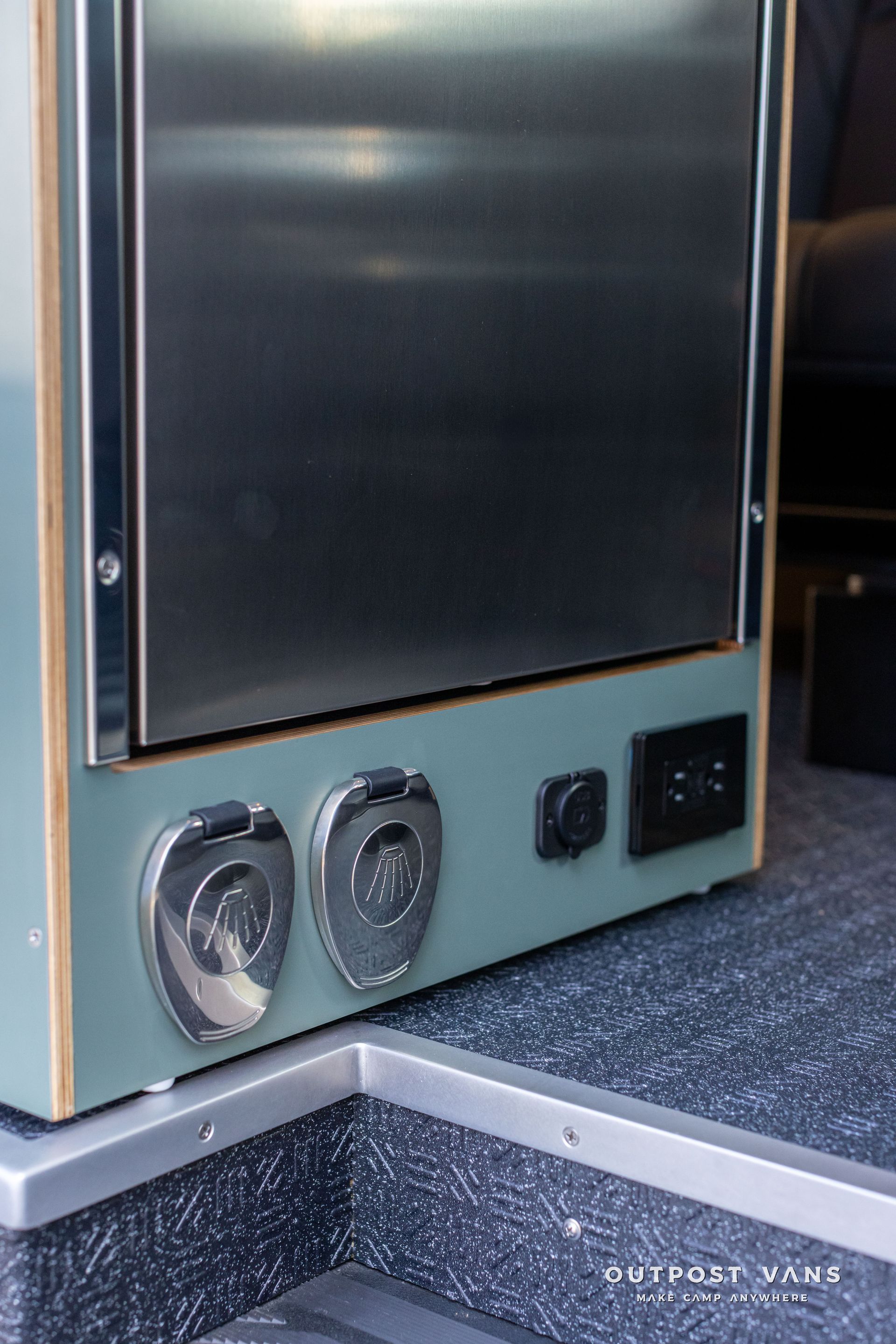 Close-up of a vintage black and silver radio or speaker console with round dials on a carpeted floor
