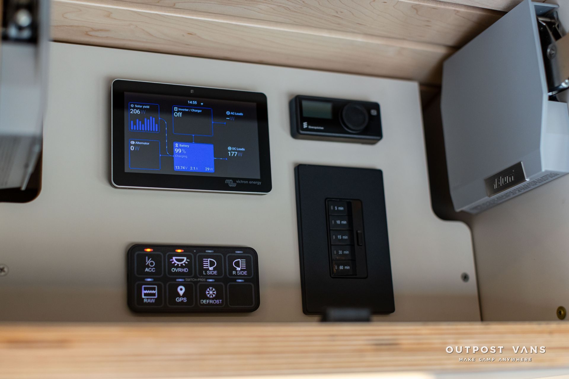 Boat control panel with touchscreen, switches, and gauges mounted on a light wood wall