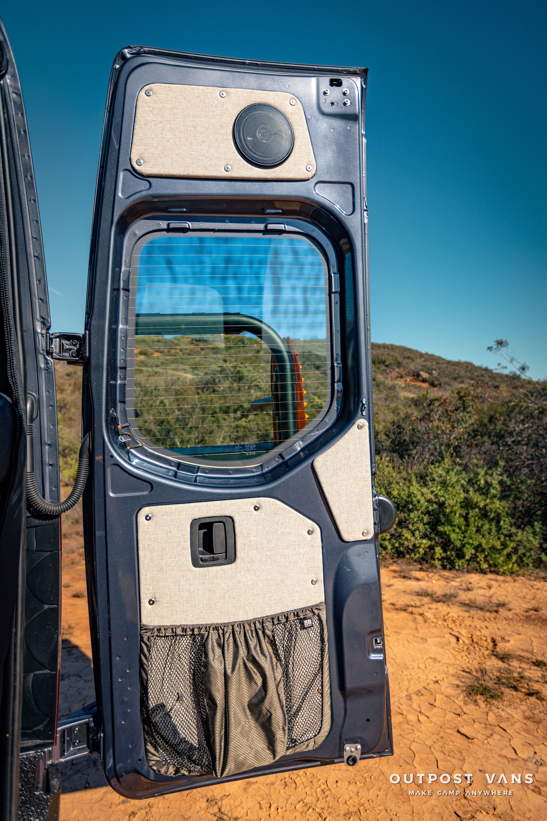 the door of a van is open and sitting in the dirt .