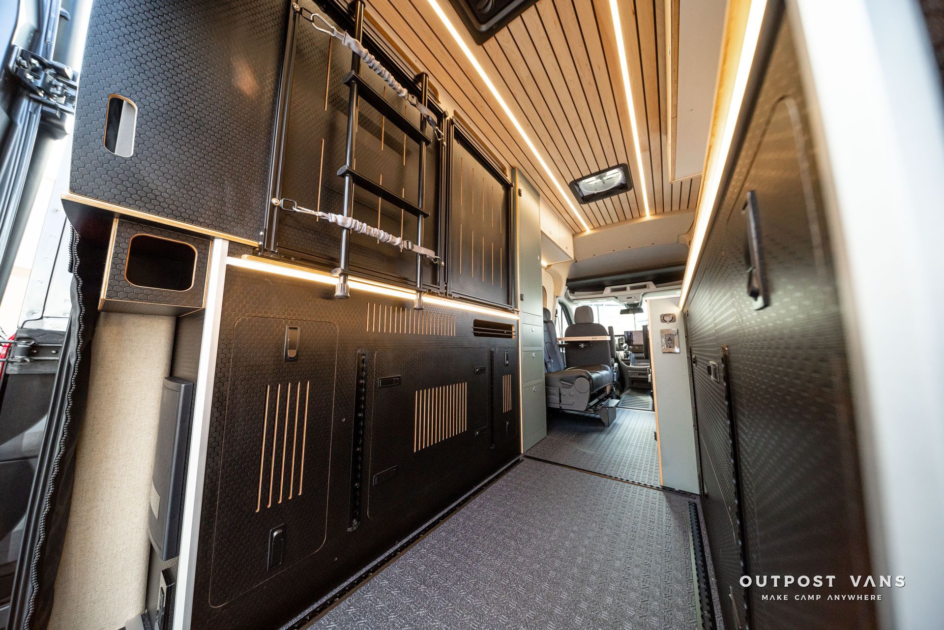 Narrow luxury RV hallway with dark cabinets, wood ceiling, and patterned floor matting