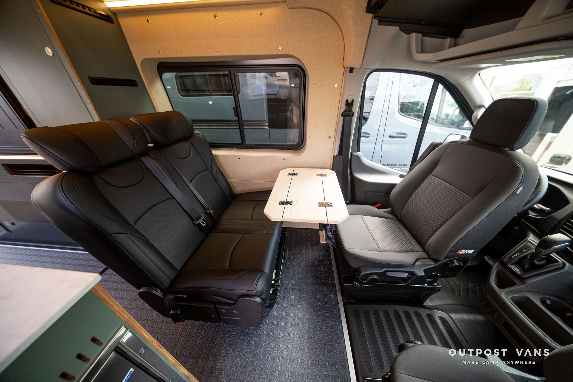 Custom van interior with two gray swivel seats and a small fold-down table between them