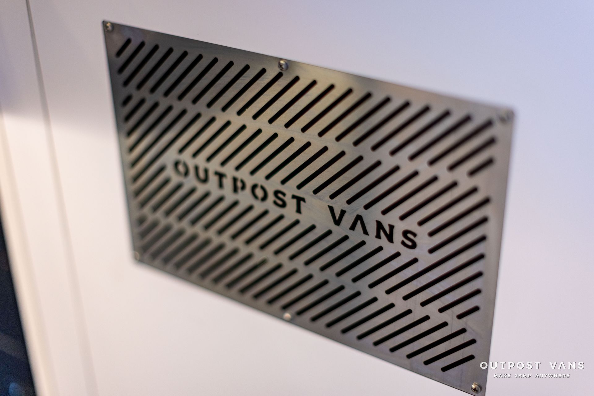 a white wall with a sign that says outpost vans on it .