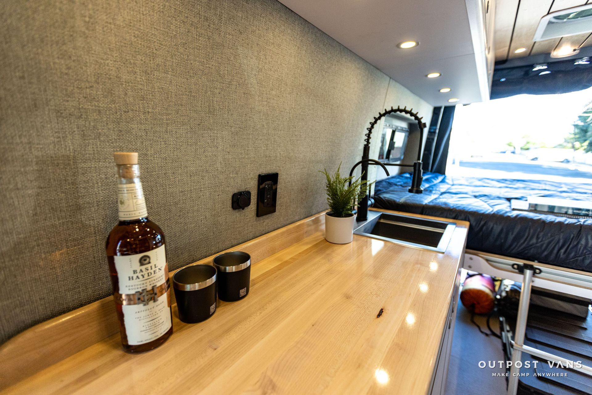 a bottle of whiskey is sitting on a wooden counter in a van .